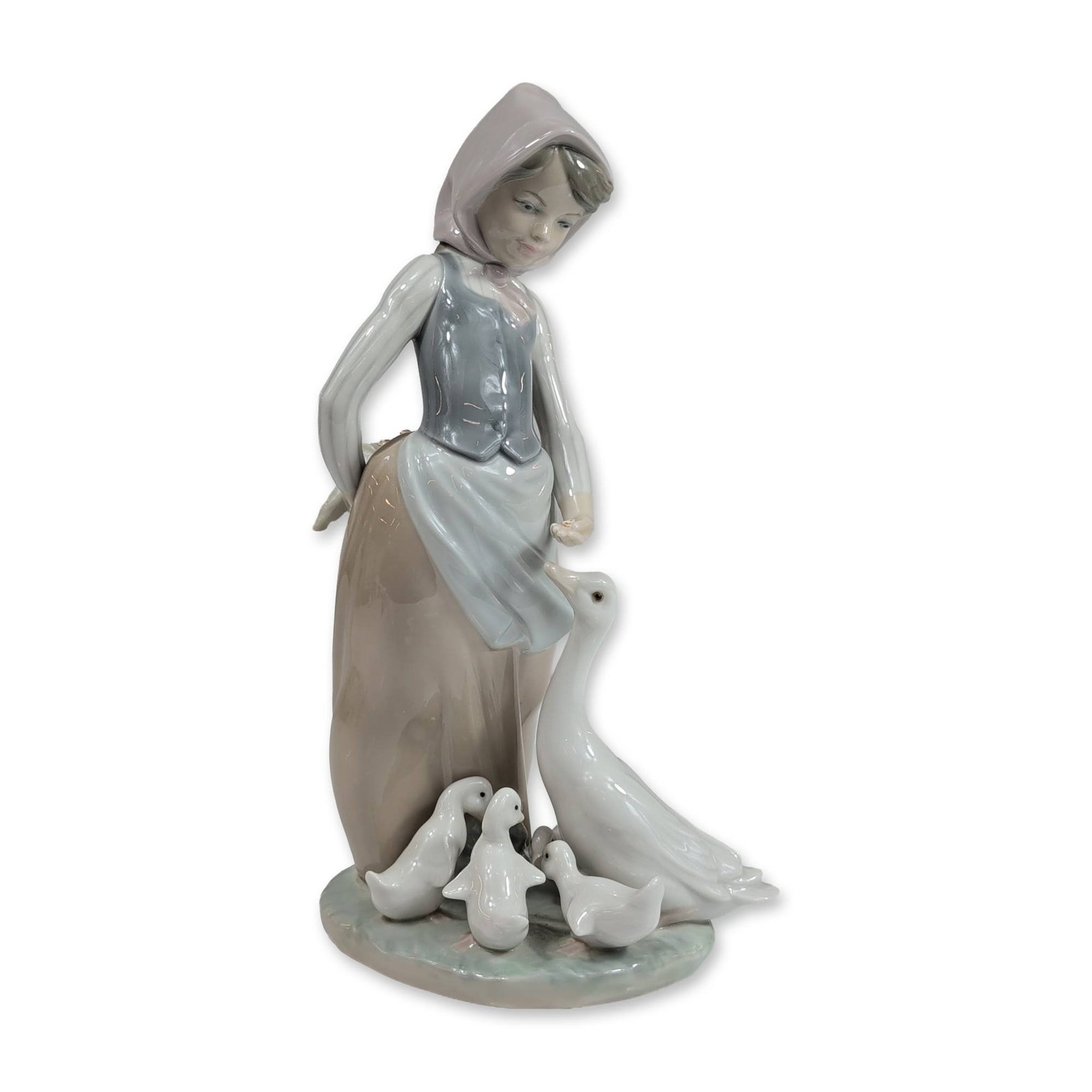 Lladro Porcelain Figurine, Feedtime 1001277: Lladro, Spain. Glazed porcelain figurine titled Goose Girl, model number 1277, depicting a young woman in rustic attire including a headscarf, grey bodice, and tan skirt. The figure is posed on a circ