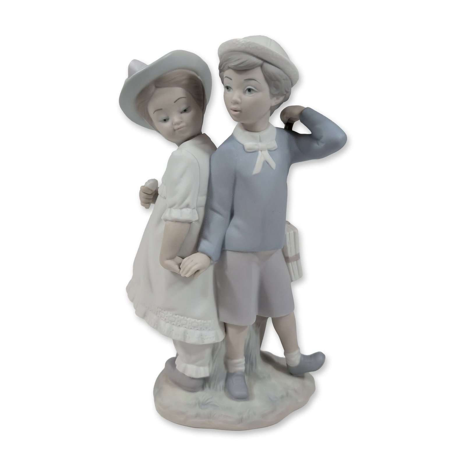 Lladro Puppy Love 1127 Porcelain Figurine: Lladro Spanish matte porcelain figurine titled Puppy Love, model number 1127. Handcrafted figure depicting a young newspaper carrier and a girl in early 20th-century attire standing on an integral tex