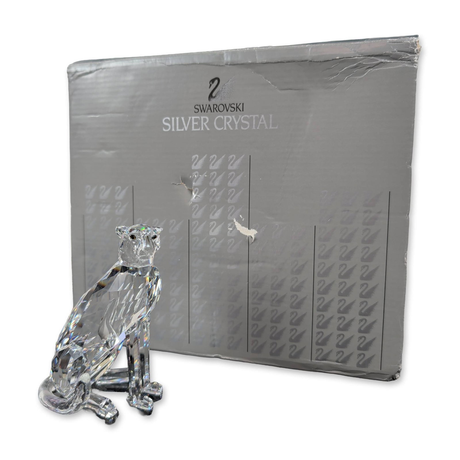 Swarovski Silver Crystal Cheetah Figurine: Swarovski faceted clear crystal figurine of a cheetah in a seated pose, part of the African Wildlife series. Designed by Michael Stamey and produced in Austria. The figurine is constructed from lead c