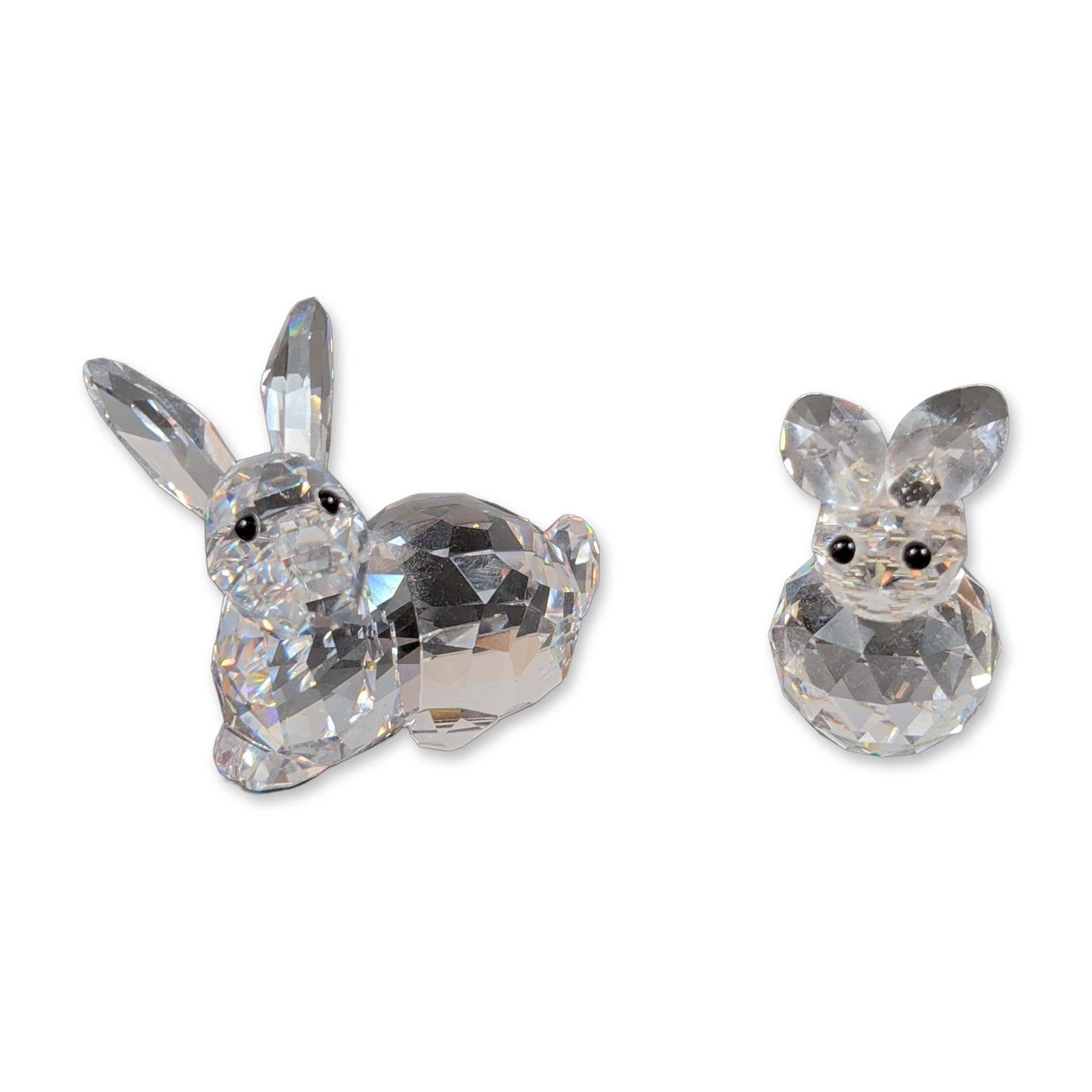 Two Swarovski Faceted Crystal Rabbits: Pair of Swarovski faceted clear lead crystal rabbit figurines, including one larger adult and one smaller juvenile figure. Each figurine features a multi-faceted body in a seated posture and is accent