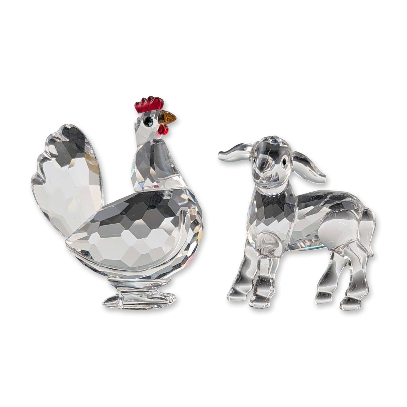 2pc Swarovski Crystal Farm Animal Figurines: Swarovski. Pair of animal figurines in faceted clear lead crystal, consisting of a standing lamb and a rooster. The goat is depicted with a faceted body and smooth face, limbs, and tail. The rooster i