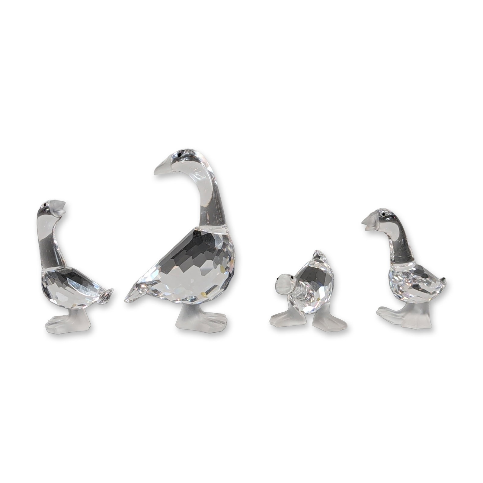 4pc Swarovski Crystal Barnyard Friends Figurines: Geese figurines in clear faceted crystal from the Barnyard Friends collection. Each piece features a multi-faceted body with smooth frosted beaks and feet. Bearing the etched Swarovski swan logo to th