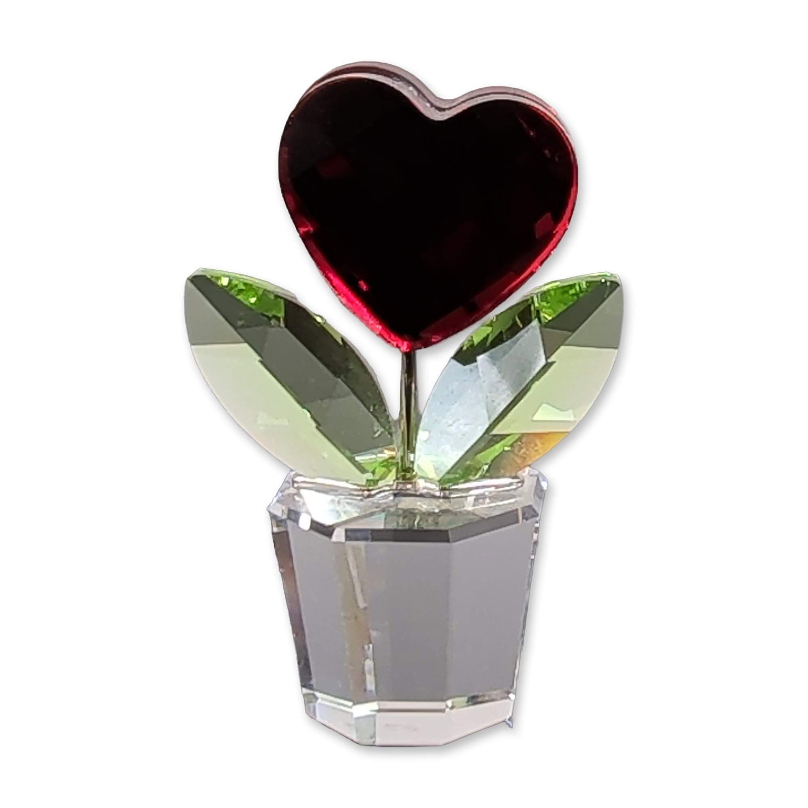 Swarovski Crystal Flower Red Heart Figurine: Swarovski. Happy Flower Red Heart figurine in faceted crystal, featuring a central vibrant red heart element flanked by two peridot-green leaves. The assembly is mounted on a clear, faceted octagonal 