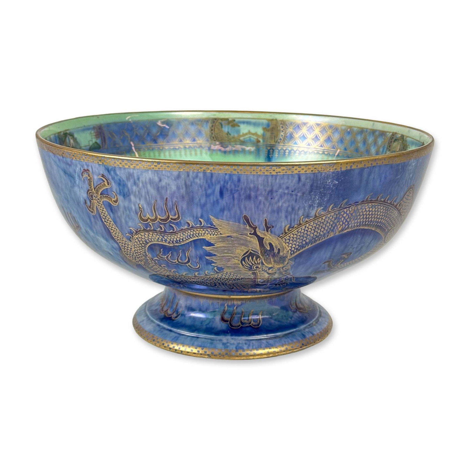 Wedgwood Dragon Lustre Porcelain Bowl, Z4829: Designed by Daisy Makeig-Jones. The exterior features a mottled deep blue luster glaze decorated with three-toed dragons in gold gilding. The interior displays a pearlescent sea-green luster ground ce