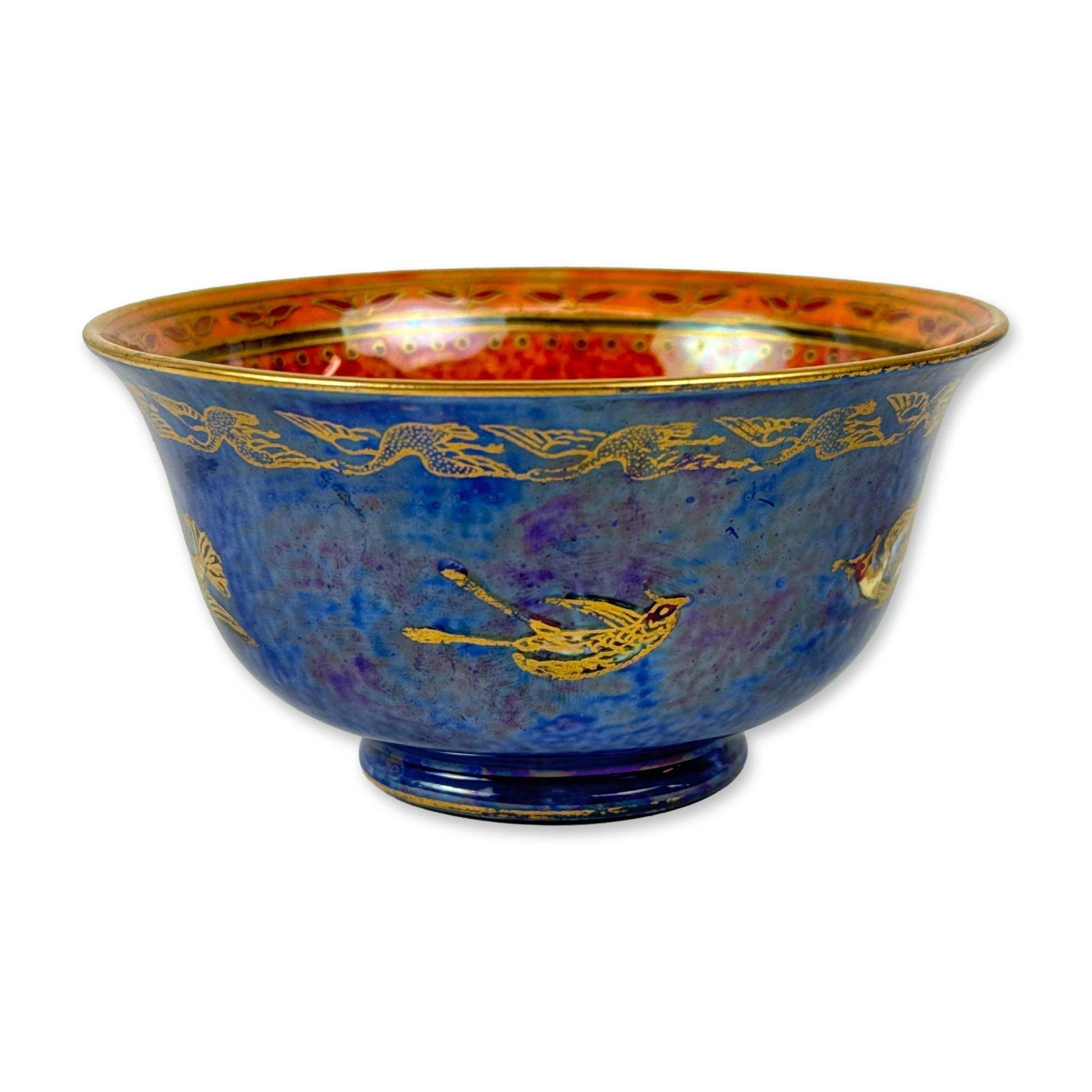 Wedgwood Hummingbird Luster Bowl, Z5294: The exterior features a mottled deep blue and purple luster ground decorated with gilded hummingbirds and a continuous frieze of geese near the rim. The interior is finished in a mottled coral-orange 