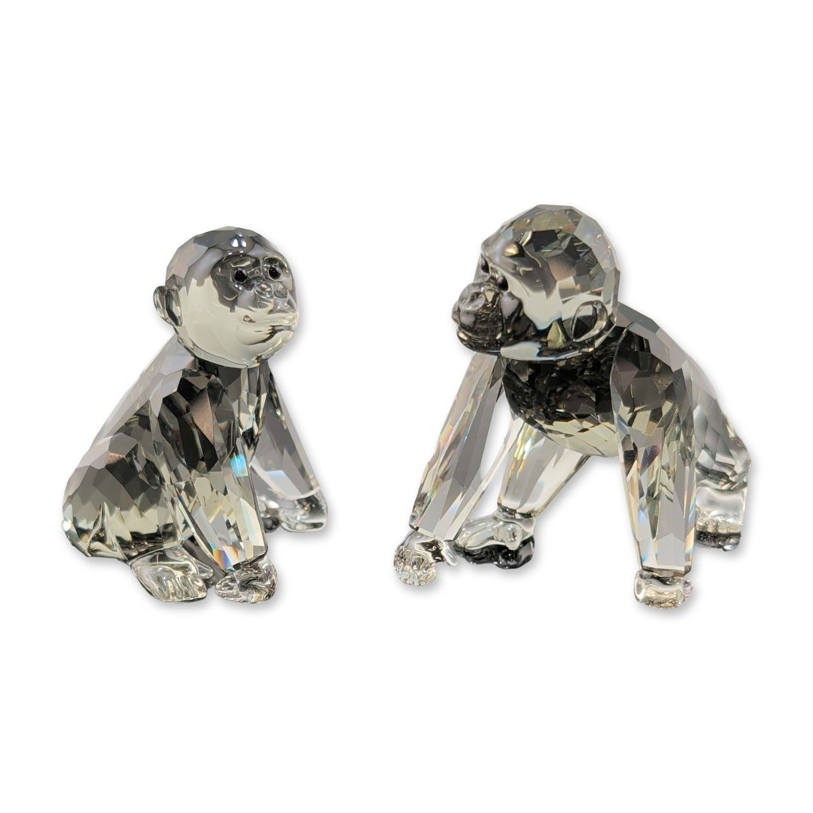 2pc Swarovski Crystal Figurines, Gorilla Cubs: Swarovski. A pair of faceted lead crystal figurines featuring gorilla cubs. Both figures are executed in Black Diamond crystal with jet crystal eyes. Both pieces feature numerous precision-cut facets 