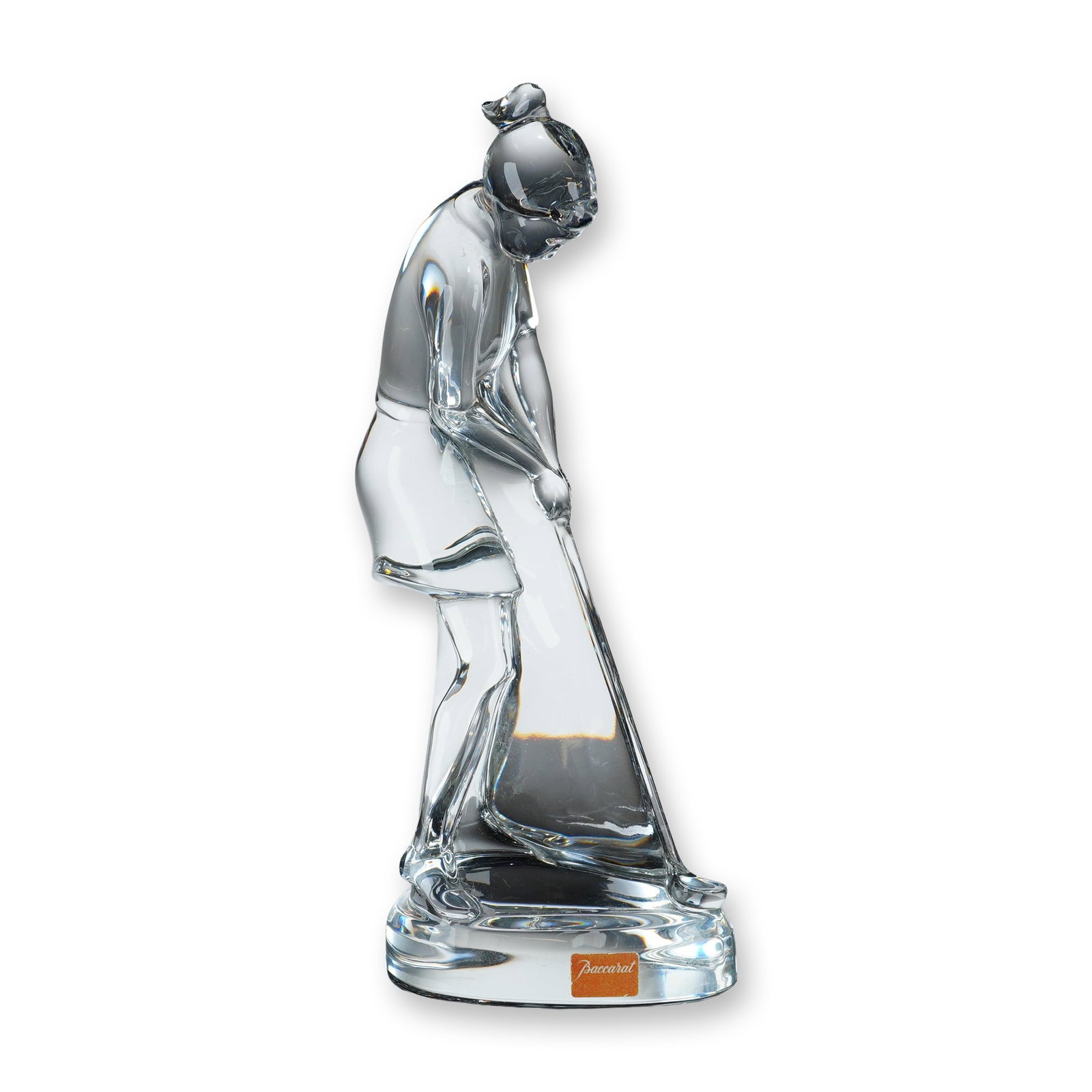 Baccarat Clear Crystal Female Golfer Figurine: Figurine of a female golfer in clear lead crystal. The stylized sculpture depicts a figure mid-swing wearing a skirt and hair styled in a bun, integrated into a thick, solid circular base. Signed with