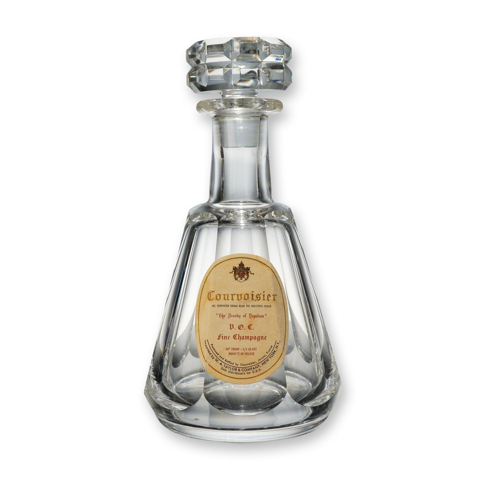 Baccarat Crystal Courvoisier Cognac V.O.C. Decanter with Stopper: This Baccarat crystal decanter, produced for Courvoisier Cognac, features a tapering octagonal body with flat-cut panels, a flared neck, and a heavy, faceted crystal stopper. The front of the vessel r