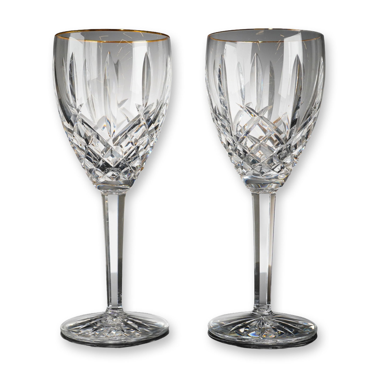 Pair of Waterford Crystal Water Goblets, Golden Araglin: Pair of Waterford lead crystal goblets in the Golden Araglin pattern, featuring gold-gilt rims. Each glass displays a bowl with hand-cut diamond and deep vertical wedge patterns, supported by a