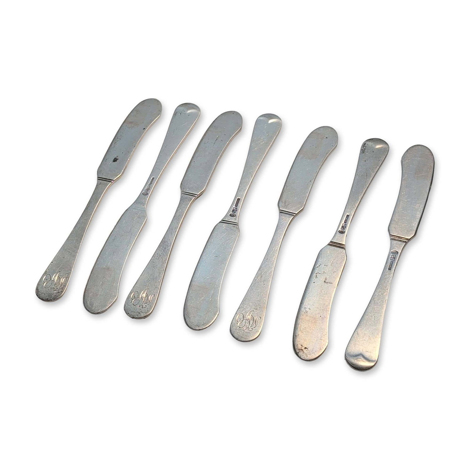 6pc Tuttle Silver Company Sterling Silver Flat Handle Butter Spreaders, Hannah Hull: Set of six sterling silver flat-handle butter spreaders, each featuring a plain handle with an engraved stylized monogram to the terminal. Reverse of handles stamped STERLING with Tuttle Silver Compan