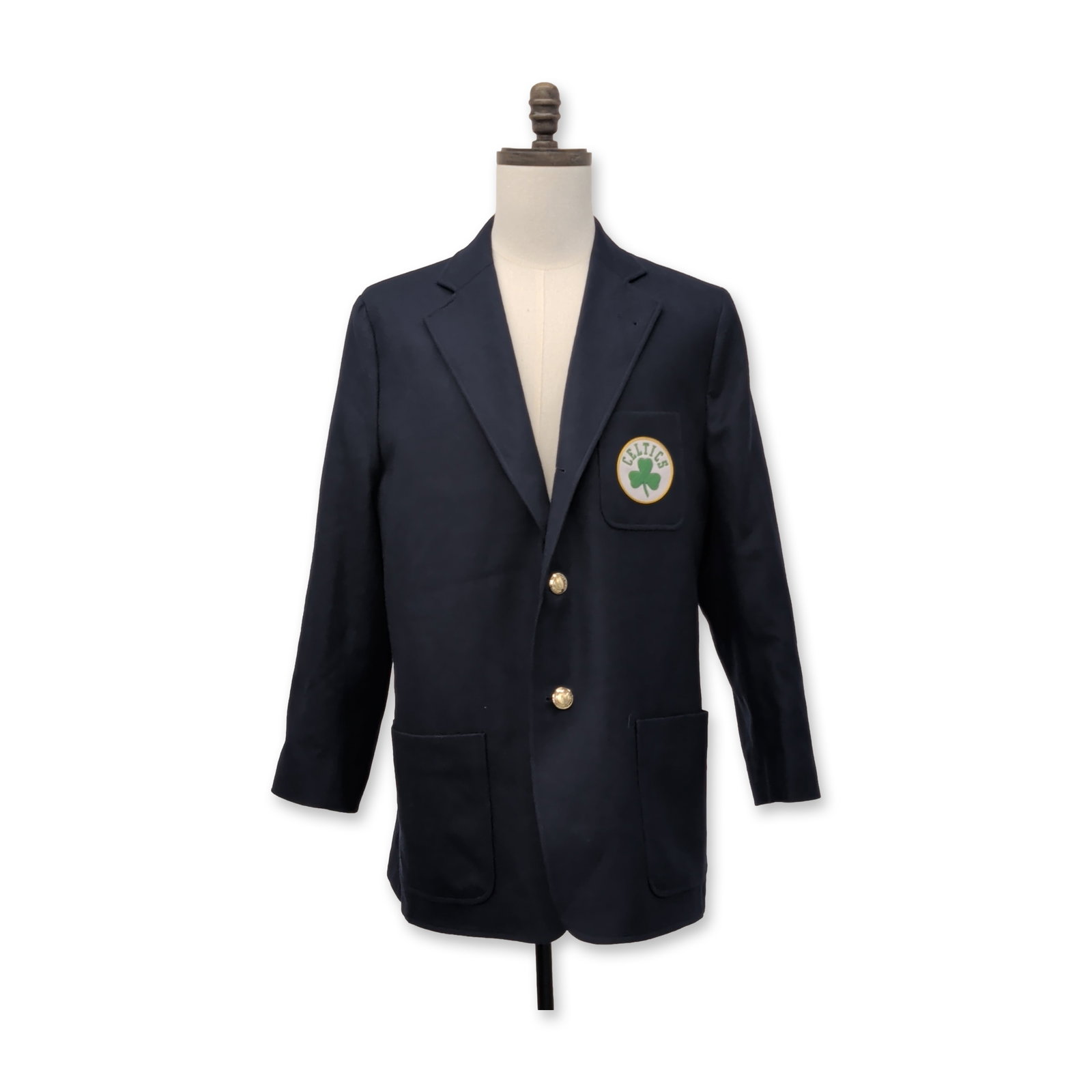 Rowing Blazers NBA Boston Celtics Navy Blue Blazer: Rowing Blazers for the NBA Boston Celtics navy blue blazer, featuring a circular chest pocket patch with a green shamrock and gold-tone buttons. The interior is finished with a woven collaboration lab
