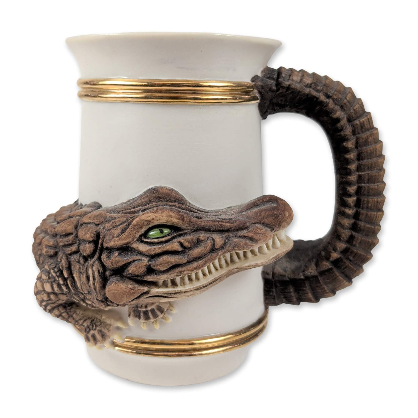 Collegiate Classics 1985 Alligator Ceramic Stein by Gary Graham for the University of Florida Gators: Featuring a textured figural alligator wrapped around the vessel body and a matching scaly handle. The white ceramic cylinder is detailed with two gold-tone bands at the rim and foot and includes a gr