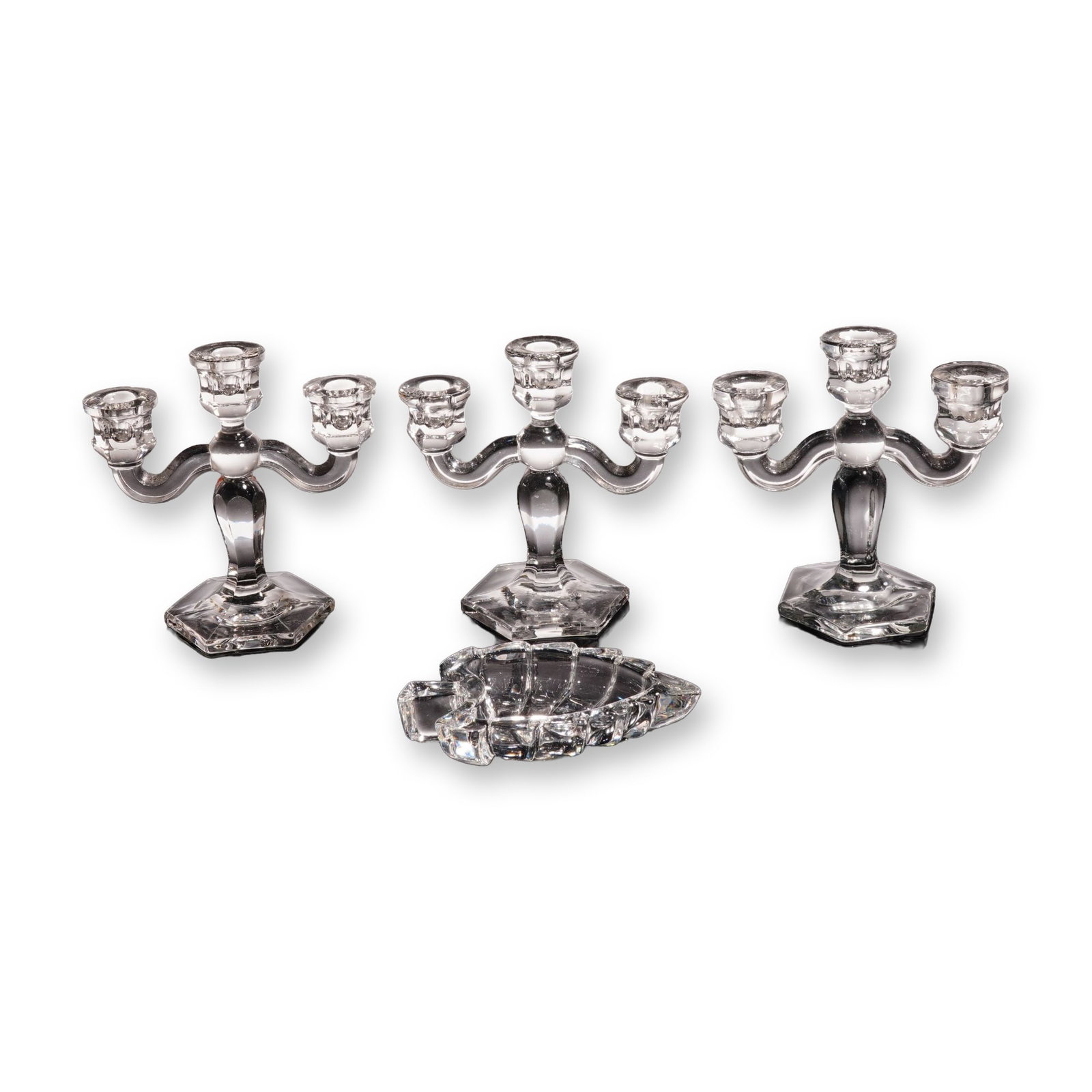4pc Clear Glass Miniature Candelabras and Leaf Dish: Each candelabrum features a central stem with a baluster-form body rising from a stepped hexagonal base, with two scrolled arms supporting outer candle sockets and a third central socket. The leaf-sha