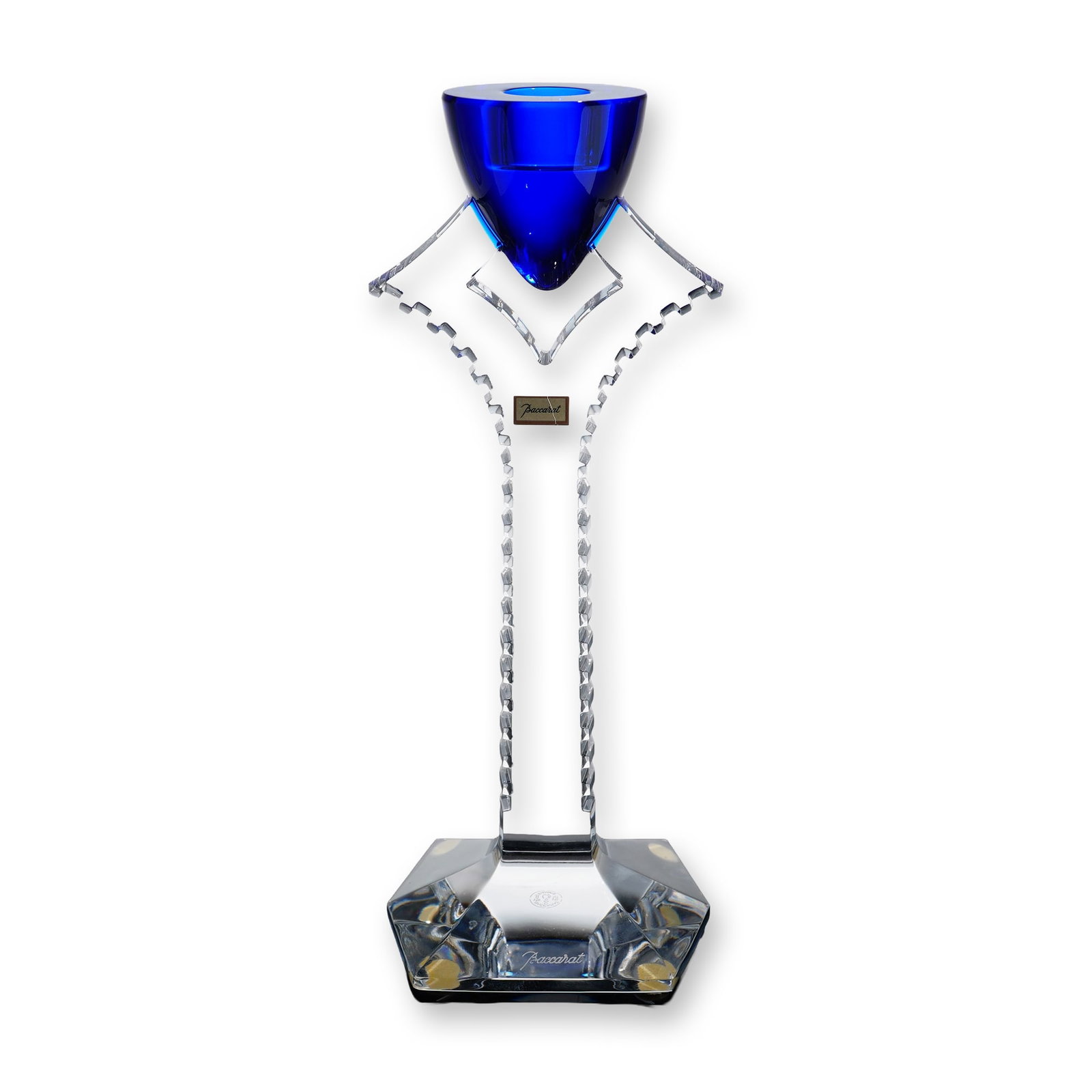 Baccarat Cobalt Blue Crystal Candlestick, Oxygene: Featuring a heavy, clear lead crystal stem with deeply notched, stepped geometric serrations along the side edges, rising from a faceted hexagonal base. The top of the clear stem splits into an angula