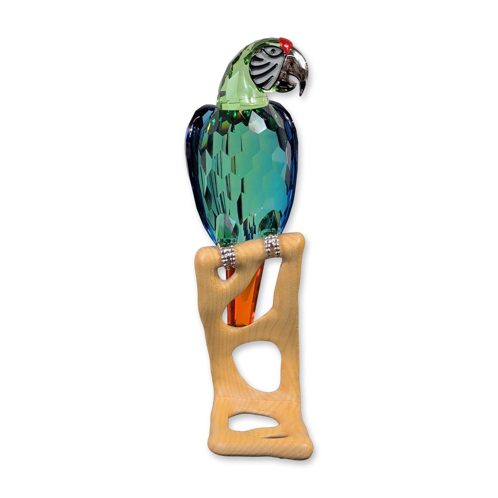 Swarovski Crystal Paradise Birds Figurine, Macaw Chrome Green: Swarovski. Paradise bird figurine in multi-colored faceted crystal, depicting a Chrome Green Macaw. The bird is designed with a pale green head featuring black and white facial markings and a red beak