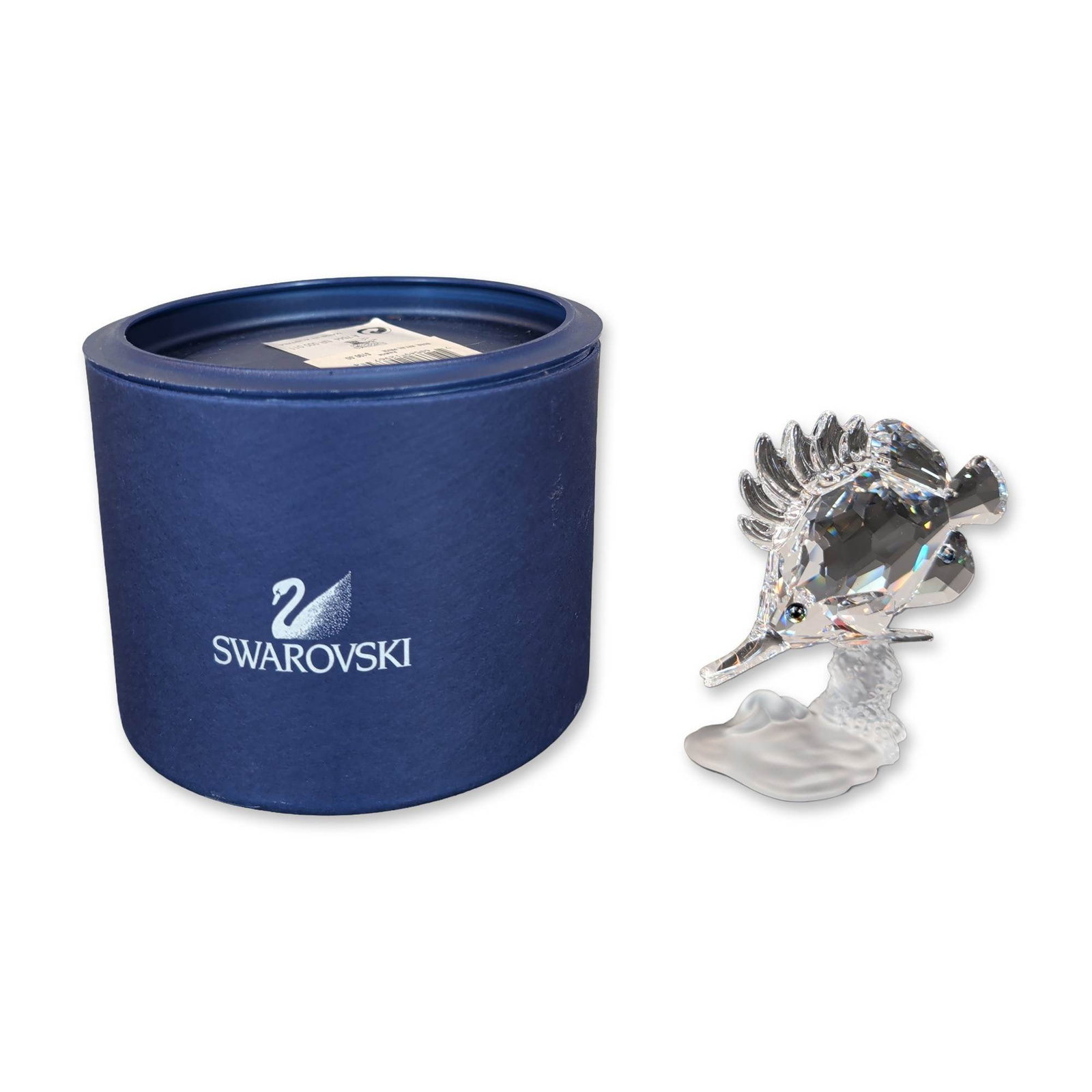 Swarovski Crystal Longnose Butterfly Fish Figurine: The Longnose Butterfly fish is depicted swimming over a frosted crystal base sculpted in a coral form. The eyes are accented with inset dark blue crystal chatons. Designed by Michael Stamey. The under