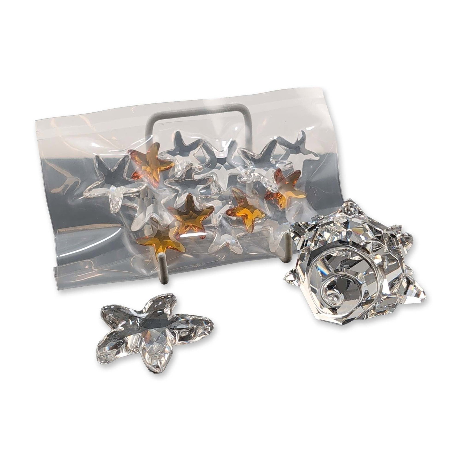 3pc Swarovski Collection of Crystal Figurines: Swarovski collection of crystal figurines including a starfish, a collection of mini starfish, and a sea shell. The sea shell figurine features a hand-etched signature M Stamey and date 10.7.94. The g