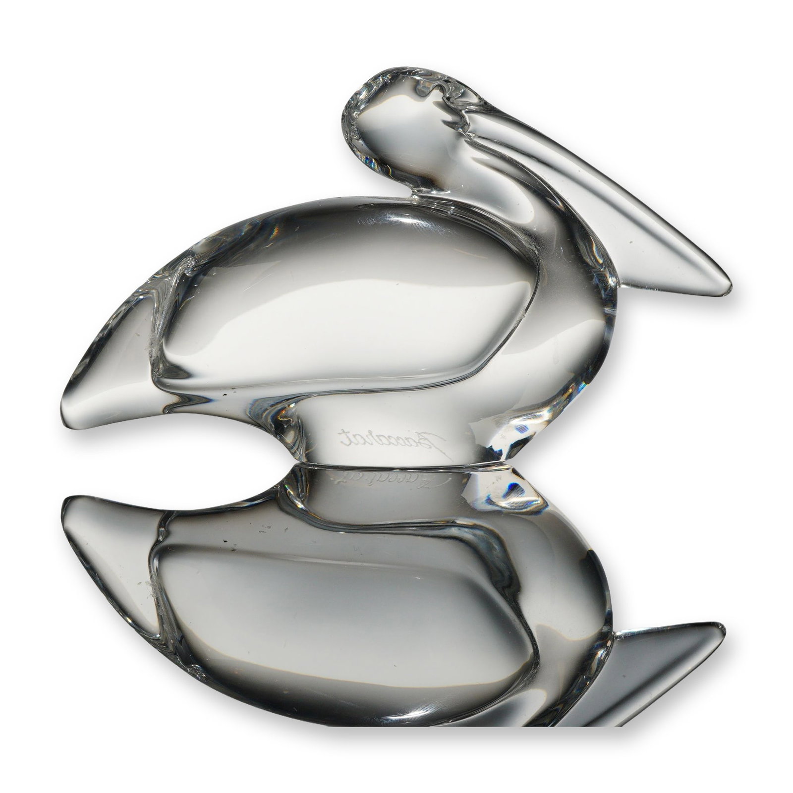 Baccarat Clear Crystal Pelican Figurine: A Baccarat clear lead crystal figurine depicting a stylized pelican in a sitting pose. The modernist sculpture features a smooth, rounded body with a long bill resting against its chest. The figurine 