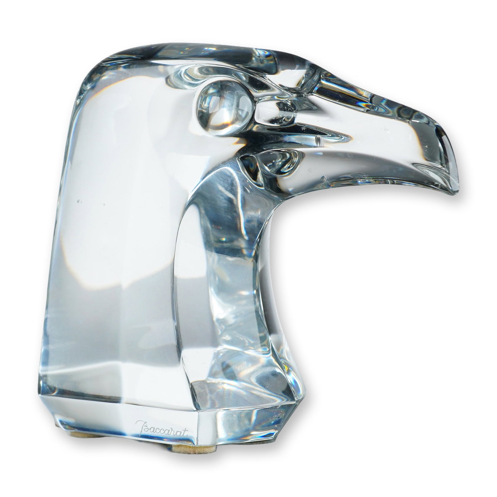 Baccarat Crystal Falcon's Head Paperweight: Modernist stylized form featuring a sharp curved beak and recessed eyes, mounted on a faceted hexagonal base. Signed with etched script Baccarat signature on the base edge and circular acid-etched fac