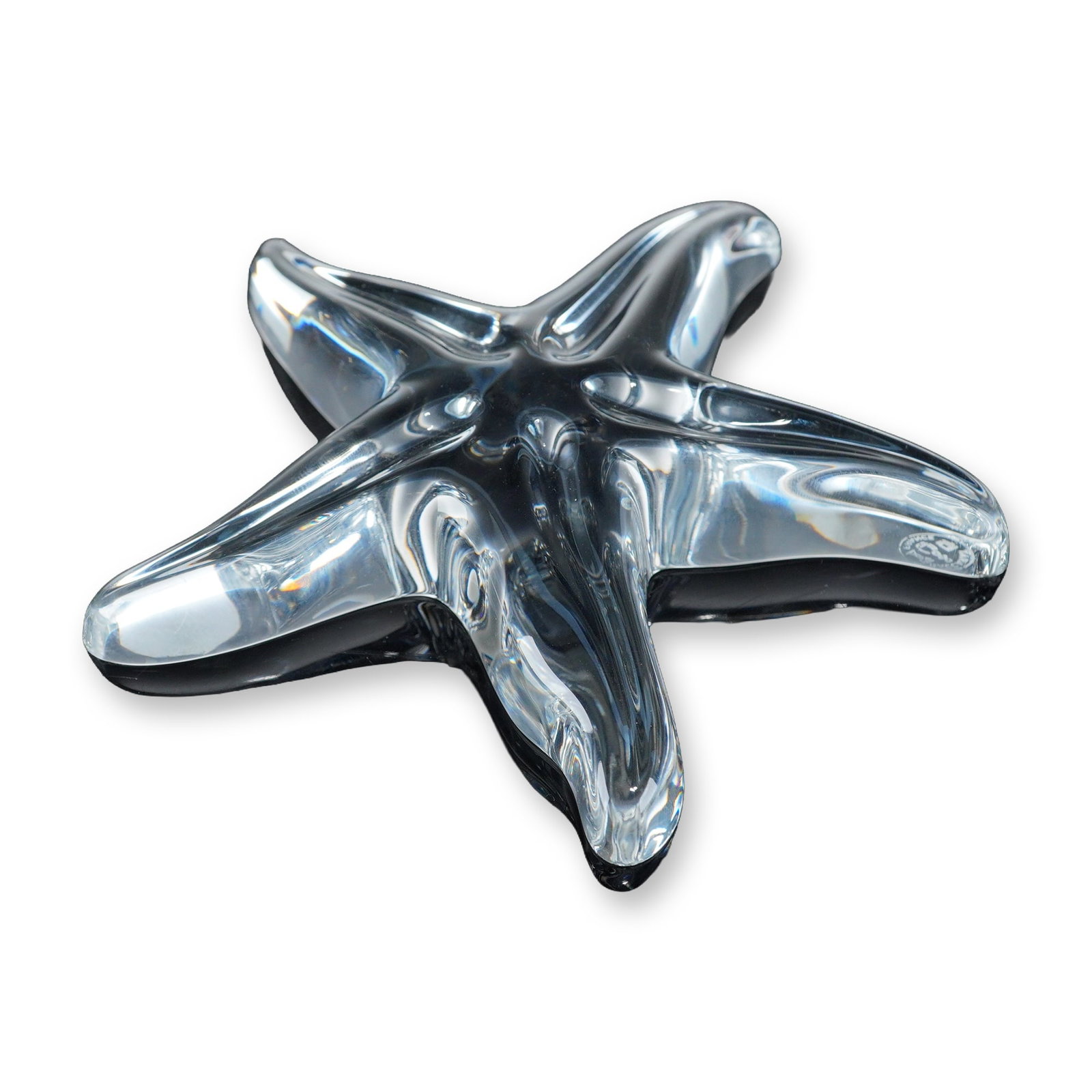 Baccarat Crystal Starfish Paperweight: Stylized five-pointed starfish paperweight or sculpture in clear lead crystal, featuring rounded contours and fluid form. The underside of one arm bears the acid-etched Baccarat circular mark containi