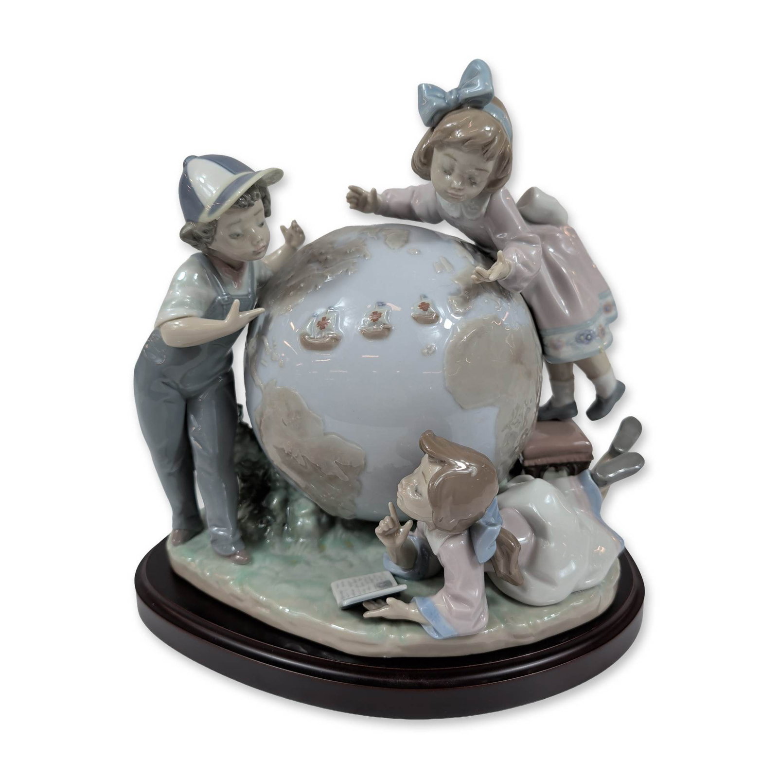 Lladro Porcelain Voyage of Columbus Figurine 5847 with Base: Lladro glazed porcelain figurine, model number 5847, titled The Voyage of Columbus. The composition depicts three children gathered around a large terrestrial globe, including a boy in a cap and overa