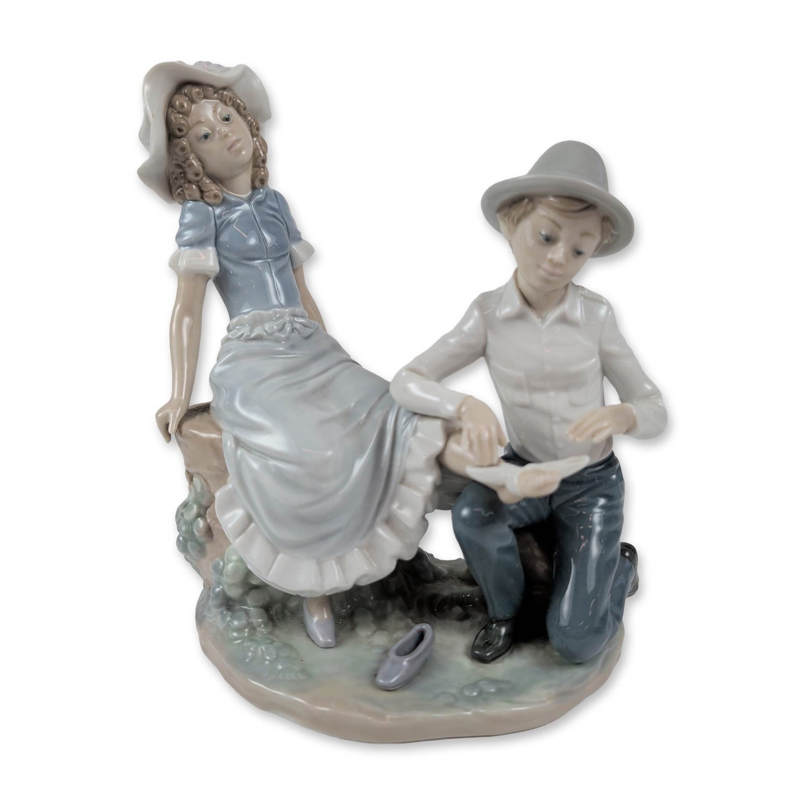Nao by Lladro Porcelain Figurine, All Better: Depicting a seated boy in a wide-brimmed hat holding a bird beside a girl in a ruffled gown, the charming scene includes the girl with a bandaged foot and a single discarded shoe on a naturalistic bas