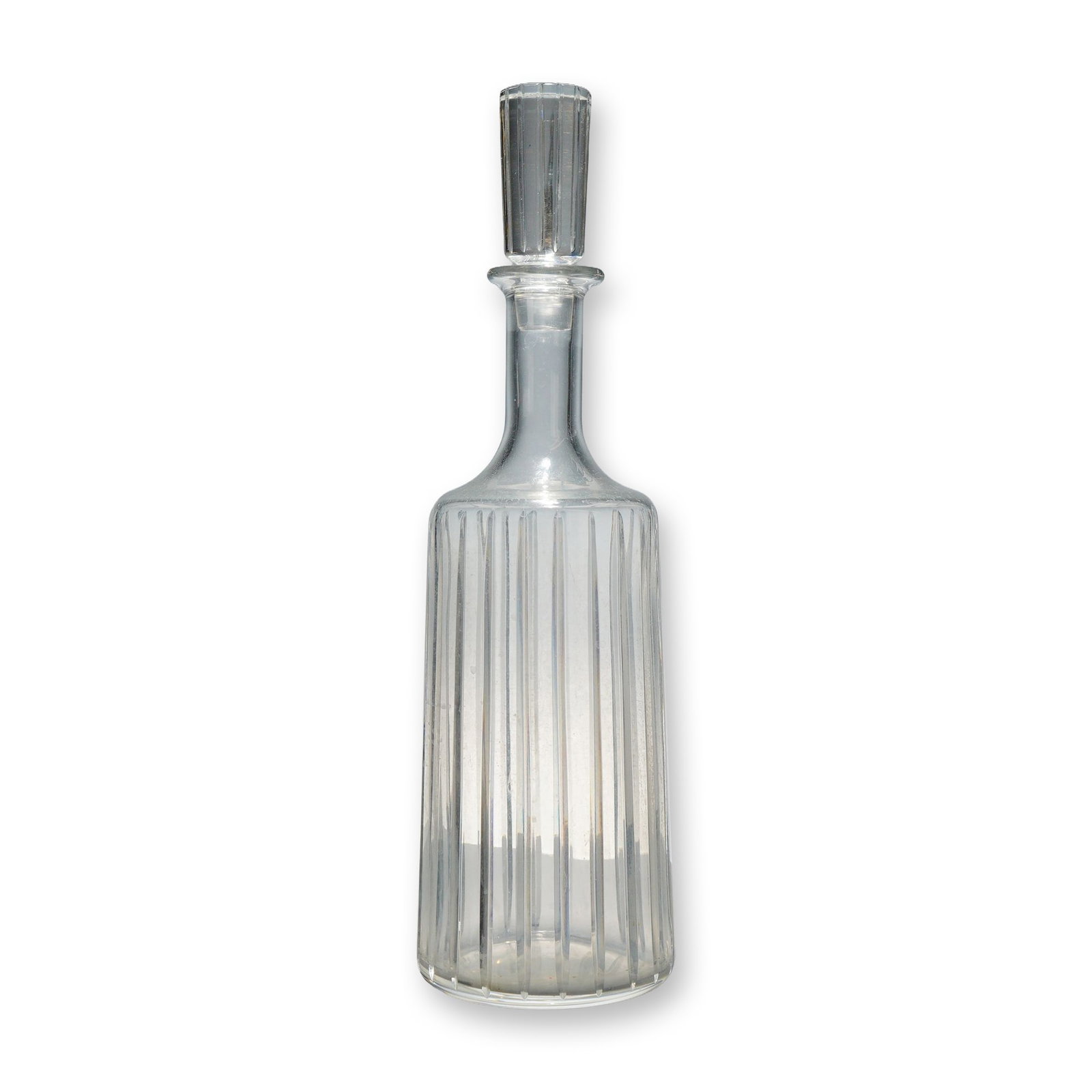 Baccarat Crystal Harmonie Round Whiskey Decanter with Stopper: A clear lead crystal whiskey decanter from the Baccarat Harmonie collection. The vessel is of cylindrical form and features a series of deep, vertical parallel fluted cuts extending from the base to t