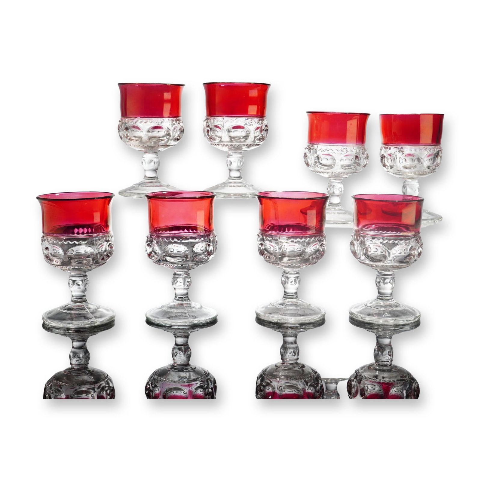 Set of 8 King's Crown Ruby Stained Brandy Glasses: King's Crown pattern, attributed to Tiffin Glass Company. Set of eight brandy glasses in pressed clear glass featuring a cranberry-colored ruby stain to the upper bowl. The design features a band of l