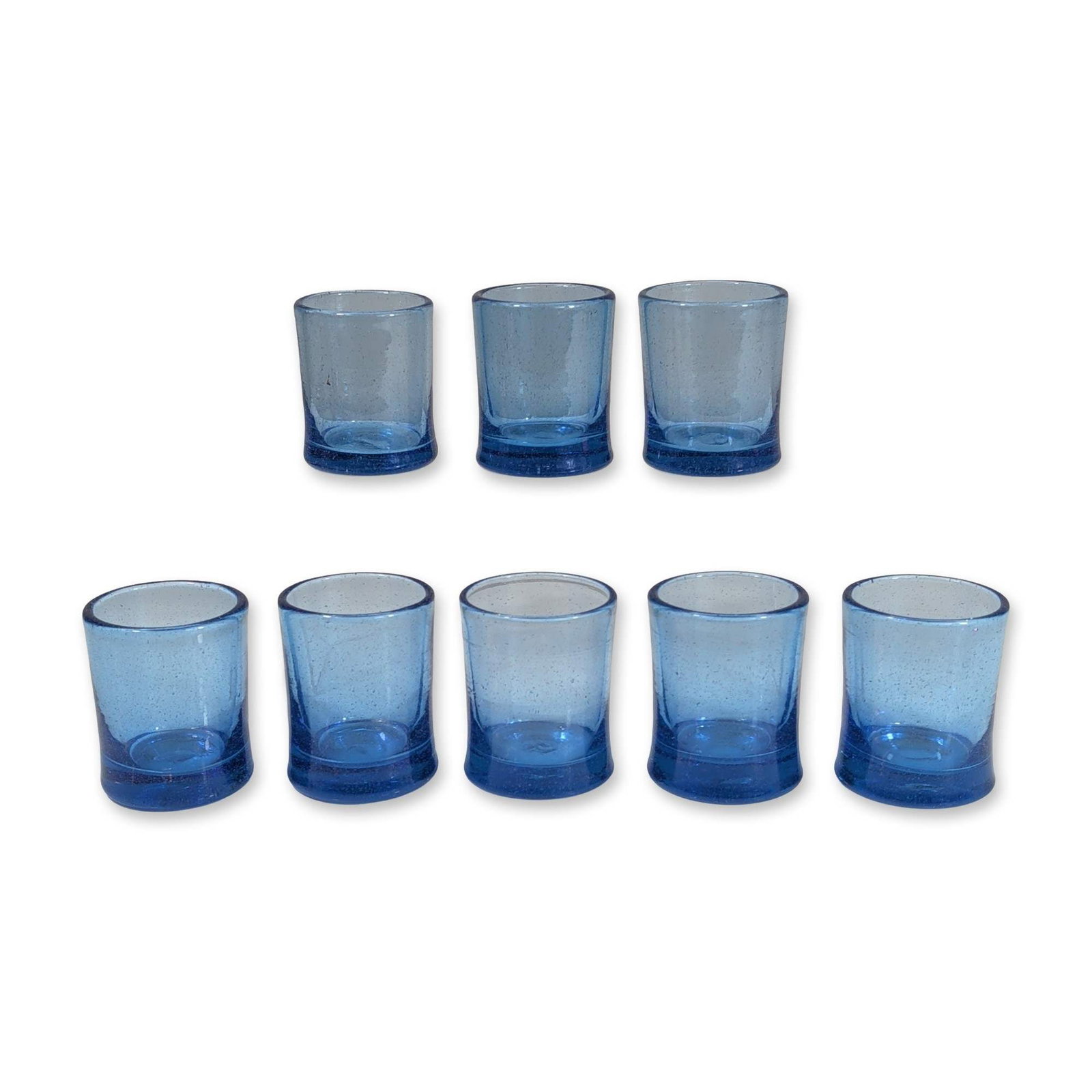 8pc Moroccan Style Blue Seeded Glass Tumblers: Set of eight tumblers in hand-blown blue seeded glass, featuring a tapered cylindrical form with a thickened base. Characterized by numerous small air bubbles trapped within the material. Bases exhibi
