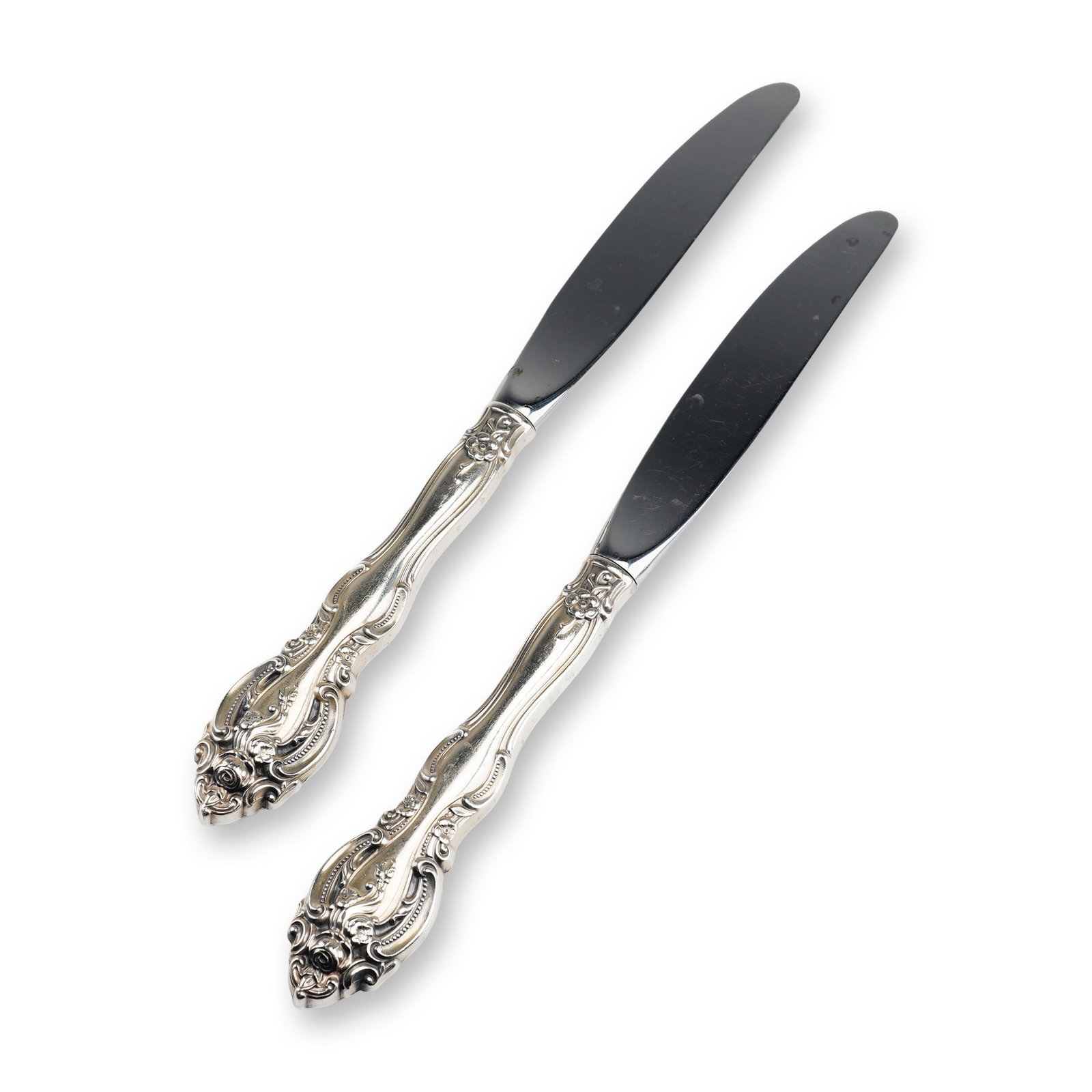 2pc Gorham Sterling Silver and Stainless Steel Dinner Knives, La Scala: A pair of dinner knives manufactured by Gorham in the La Scala pattern. The handles are constructed of sterling silver and feature a highly ornate Rococo-revival design with elaborate scrollwork, flor
