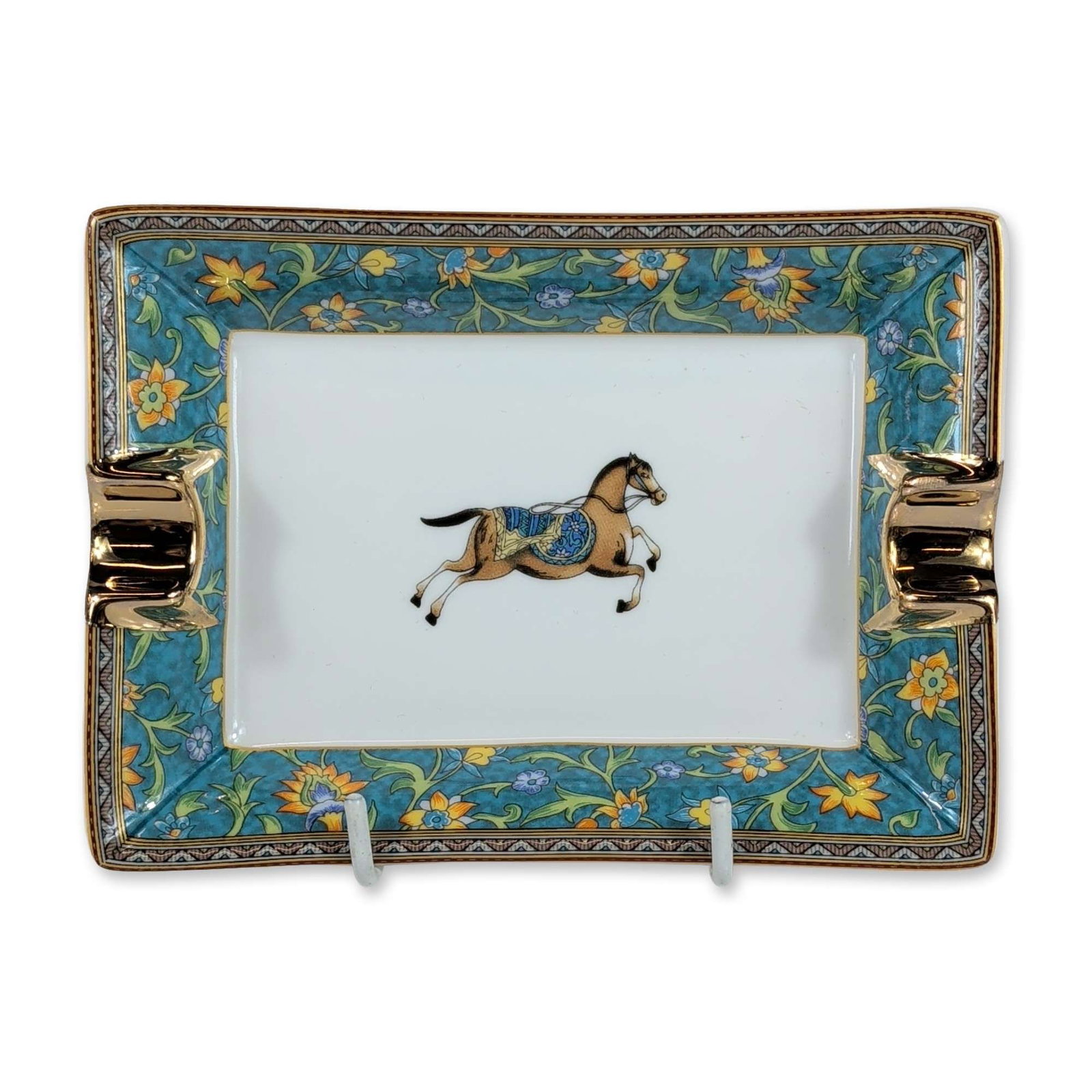 Hermes Paris Cheval d Orient Porcelain Ashtray: Hermes porcelain ashtray in the Cheval d Orient pattern, featuring a central caparisoned horse motif in the style of Persian miniatures. The sloped border is finished in a turquoise ground with yellow