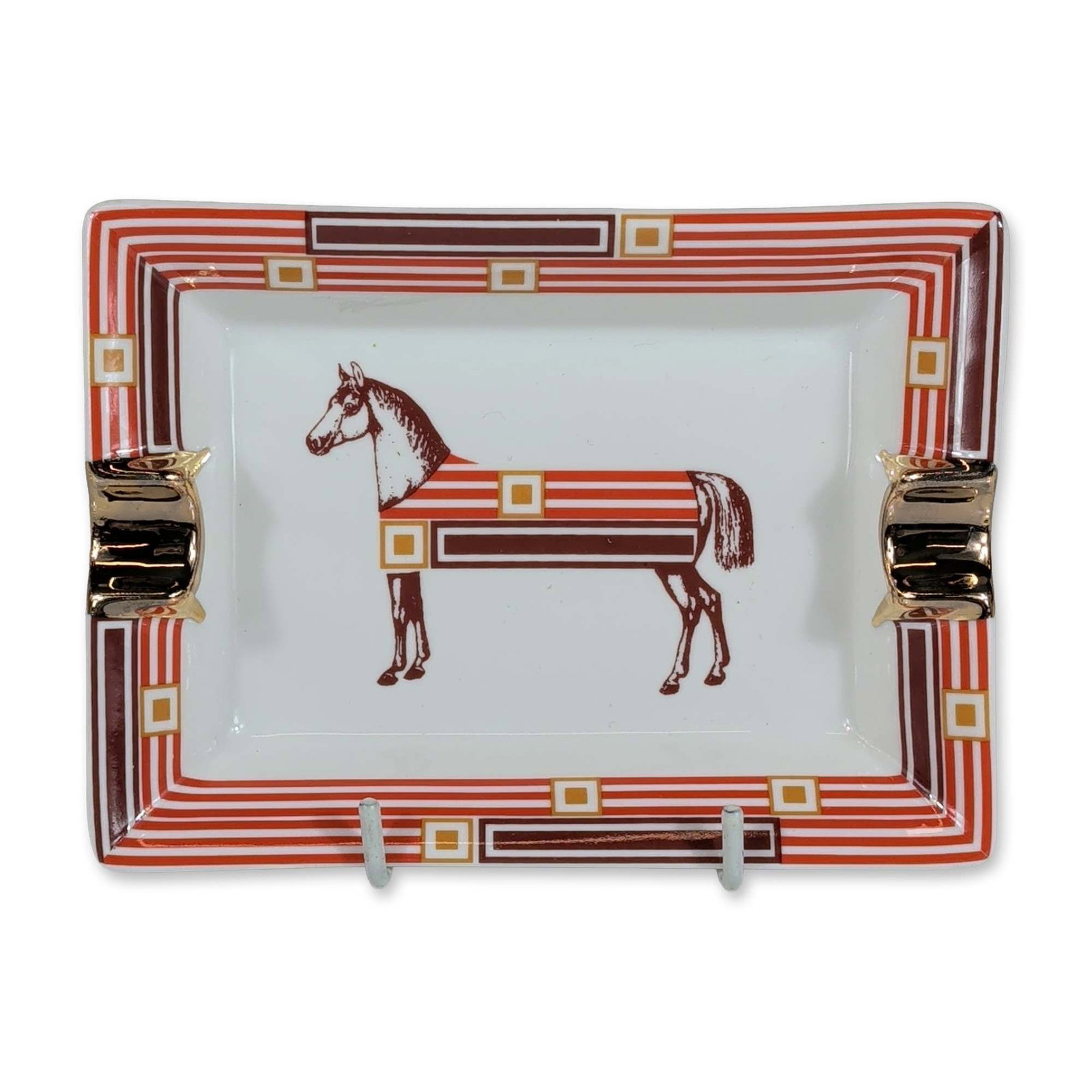Hermes Paris Cheval D'Orient Porcelain Ashtray: Hermes, Paris, rectangular ashtray in white porcelain, featuring the Cheval D'Orient pattern with a stylized horse motif in geometric patterns of brown, orange, and yellow. The piece is designed with 
