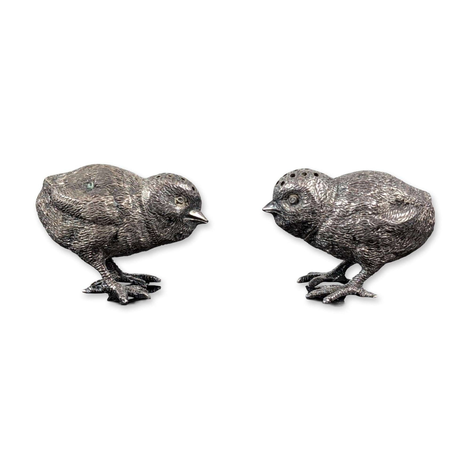 Edwardian WH London Sterling Silver Chick Shakers: A charming pair of sterling silver salt and pepper shakers designed as lifelike chicks, complete with textured feathers and four-toed feet. The removable heads have different perforations for dispensi