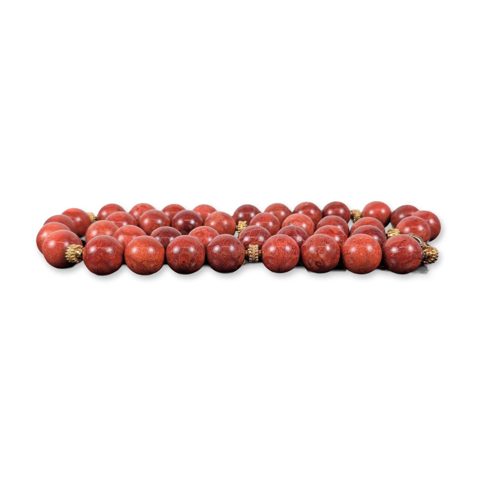 Large Red Sponge Coral Beaded Necklace: Single strand beaded necklace composed of large, round red sponge coral beads. The beads exhibit a natural porous structure and mottled reddish-brown coloration. Several gold-tone metal spacers with g