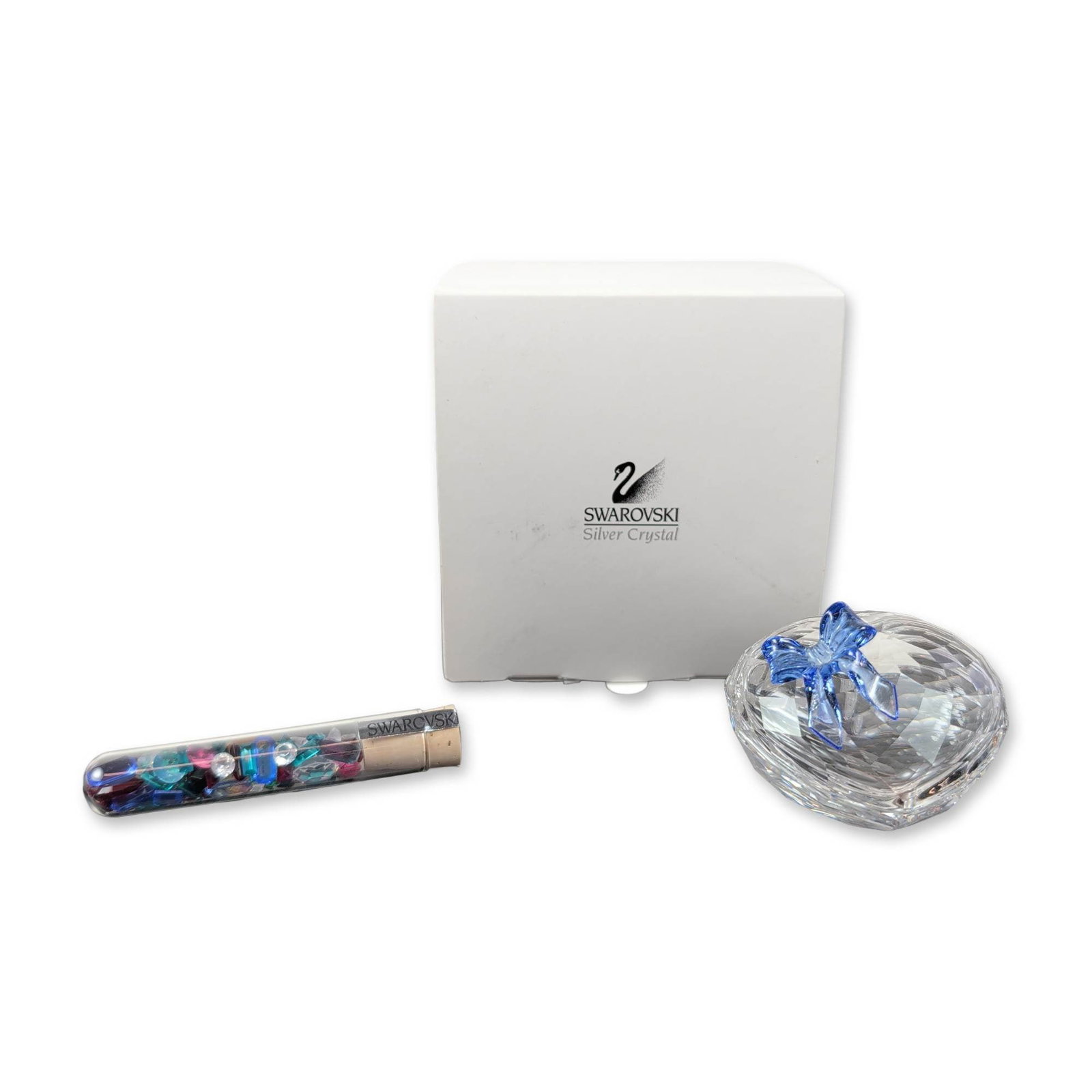 Swarovski Crystal Sweet Heart Jewel Box and Vial of Crystals Chatons: Swarovski Sweet Heart jewel box in faceted clear crystal, featuring a lid accented with a blue crystal bow. Set includes a glass vial with cork stopper containing a variety of multi-colored faceted cr