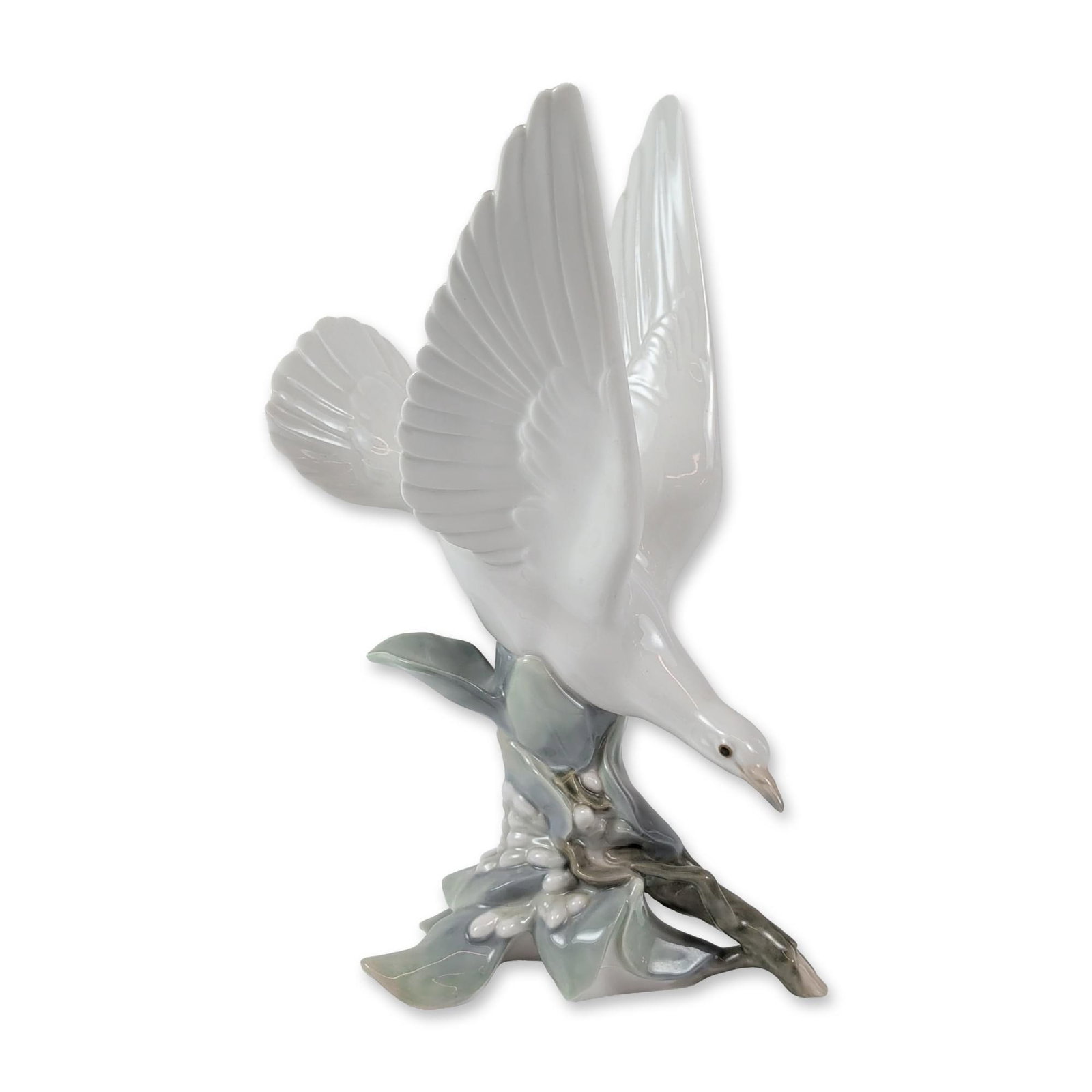 Lladro Porcelain Turtle Dove Figurine: (Model #4550), depicting a white bird in flight landing on a stylized branch with green leaves and clusters of white berries. The piece is finished with a high-gloss glaze. The underside features the 