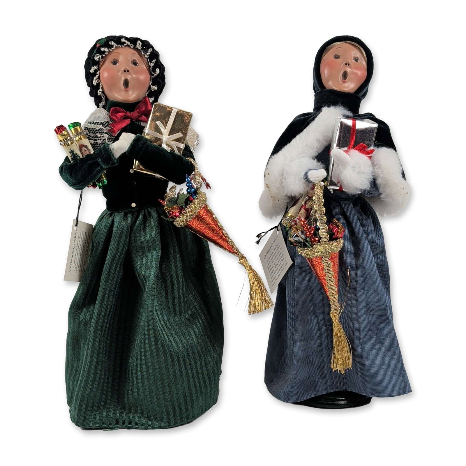 2pc Byers Choice Victorian Style Caroler Figurines: Byers Choice Ltd., pair of handcrafted caroler figurines from The Carolers line. Each figure features a hand-painted composition head with an open mouth in a singing expression and fixed eyes, constru