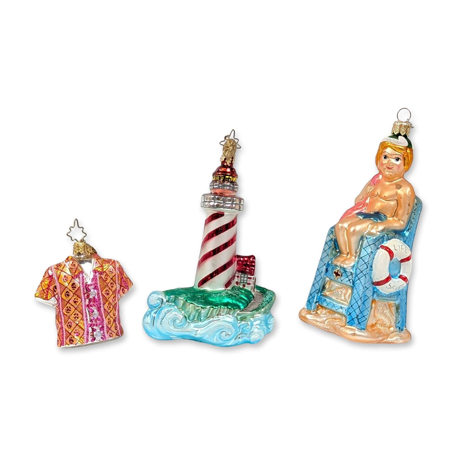Three Christopher Radko Blown Glass Beach Ornaments: Christopher Radko. Trio of hand-painted, mouth-blown glass ornaments featuring summer and nautical themes. The group includes a Hawaiian-style shirt ornament with a geometric pattern on the front and 