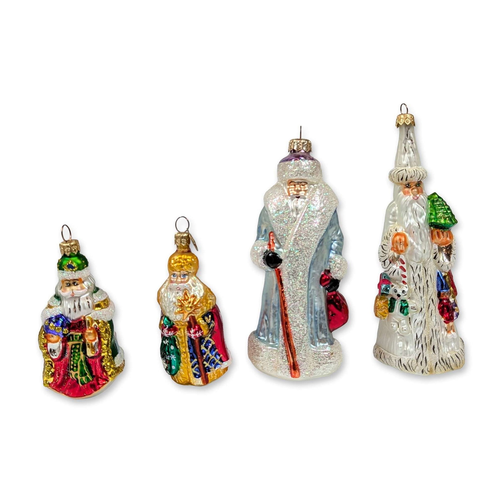 Set of Four Christopher Radko Santa Claus Ornaments: Christopher Radko. Set of four hand-blown glass Christmas ornaments featuring traditional Father Christmas figures in various ceremonial robes and hats. The group includes a figure in a green miter