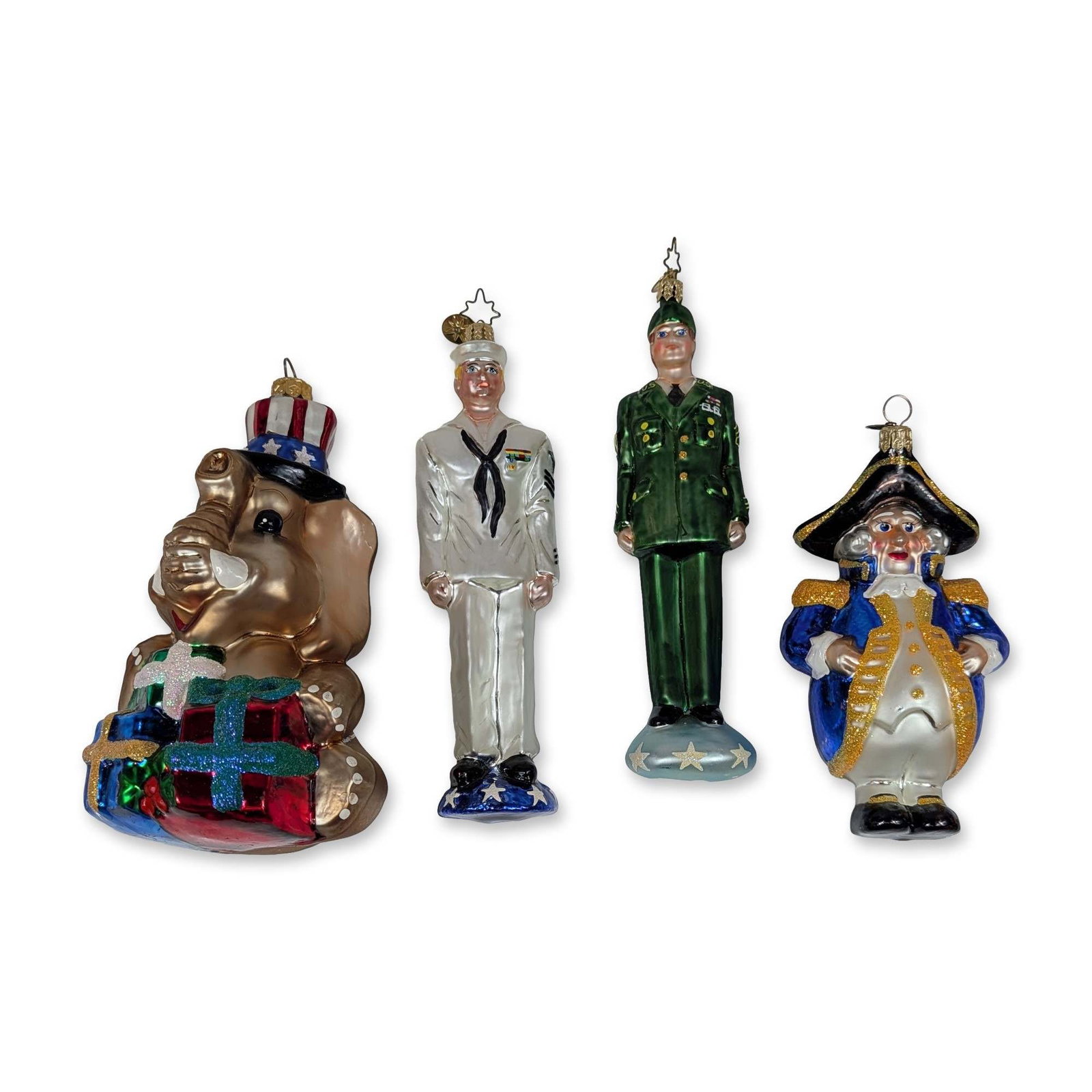 4pc Christopher Radko Glass Ornaments: Christopher Radko. Group of four hand-blown glass Christmas ornaments featuring patriotic and military themes. The collection includes a metallic gold elephant wearing an Uncle Sam hat and holding