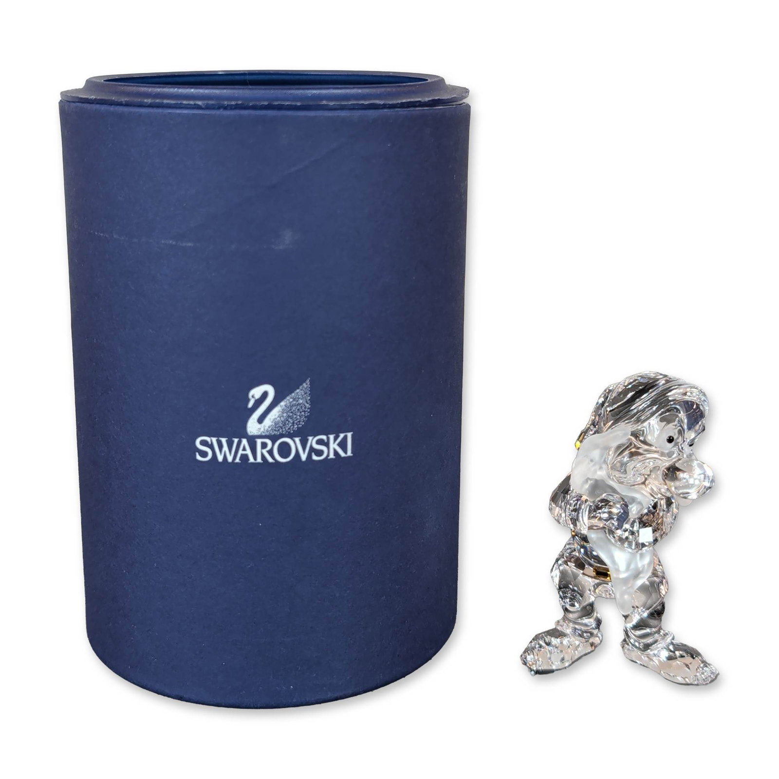 Swarovski Crystal Disney Snow White Grumpy Figurine: Figurine in clear faceted lead crystal depicting the Disney character Grumpy from Snow White and the Seven Dwarfs. The figure features a faceted clear crystal body and hat, contrasted with a frosted c