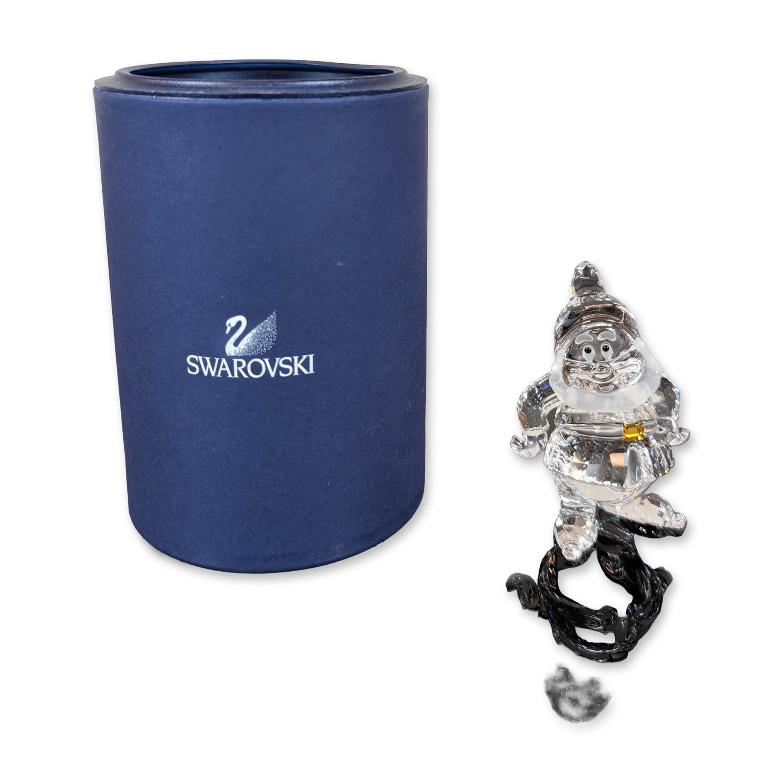 Swarovski Crystal Disney Snow White Happy Figurine: Swarovski Disney series Happy dwarf figurine in faceted clear lead crystal, featuring a frosted crystal face and collar accented with a gold-tone metal belt buckle. Part of the Snow White and the Seve