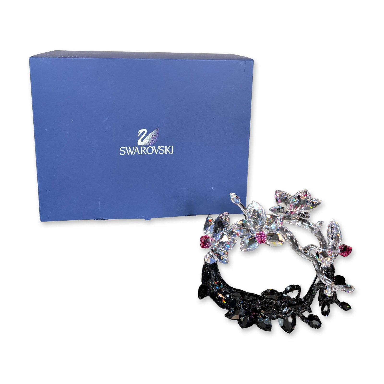 Swarovski Crystal Orchids on a Vine: Orchids on a Vine figurine, in faceted lead crystal, featuring a clear crystal branch with five-petaled blossoms and closed buds. Flower centers and buds are accented with faceted pink-magenta crystal