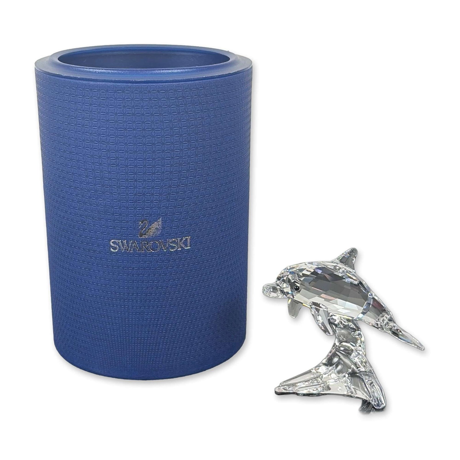 Swarovski Crystal Dolphin Baby Figurine: Swarovski crystal model 5043633 is a beautifully crafted piece in faceted clear lead crystal, showcasing a dolphin in mid-leap. The base features an acid-etched Swarovski swan logo next to a copyright