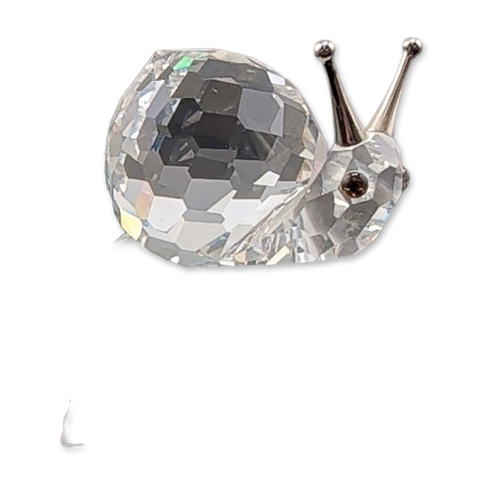 Swarovski Crystal Snail on Leaf Figurine: Swarovski Silver Crystal figurine in faceted and frosted lead crystal, depicting a snail resting on a leaf. The snail features a large faceted spherical shell and head with metal antennae. The base is