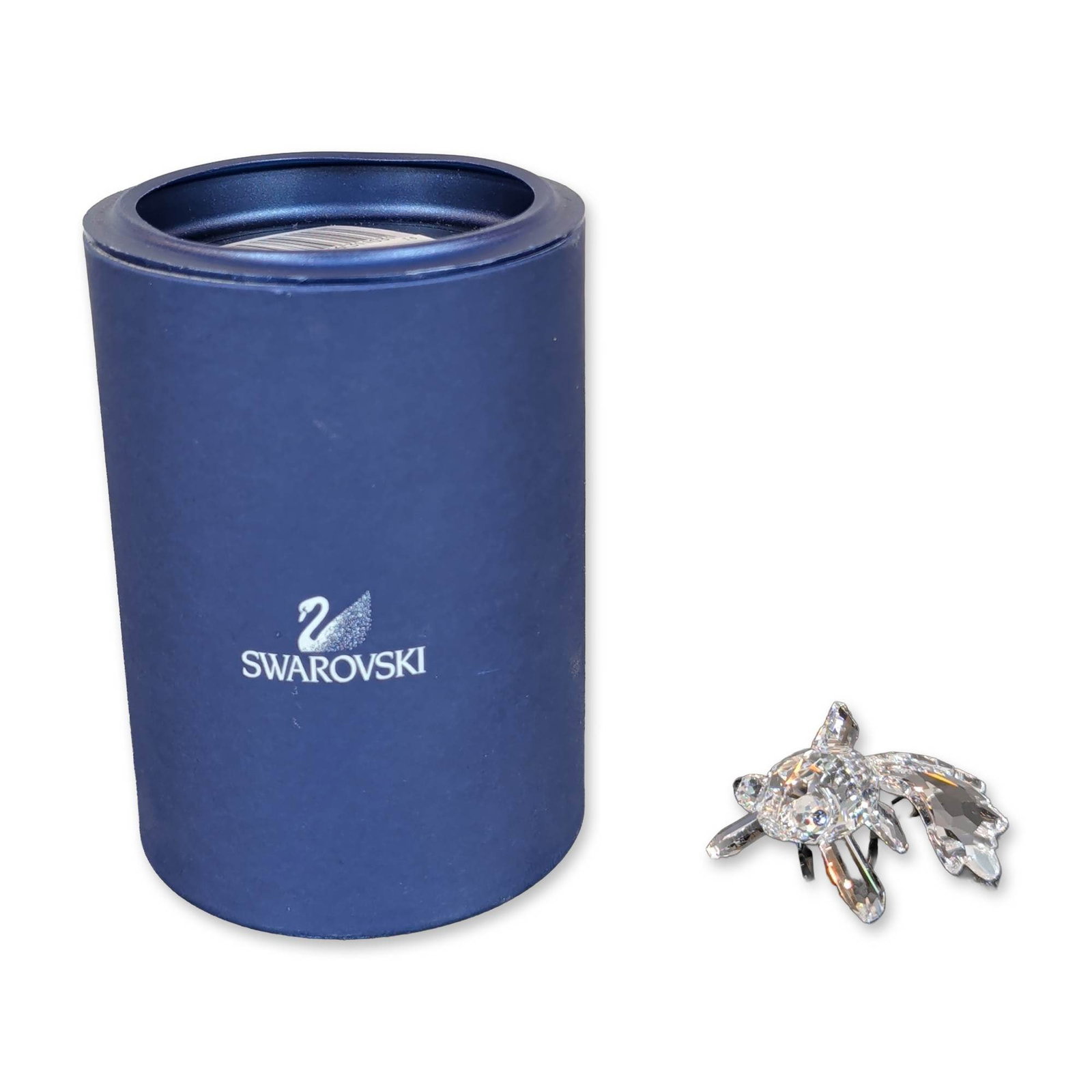Swarovski Crystal Telescope Fish Figurine: Swarovski Crystal figurine depicting a telescope fish. Crafted from faceted clear lead crystal, the piece features a multi-faceted body with a detailed fanned tail and inset dark crystal accents for e