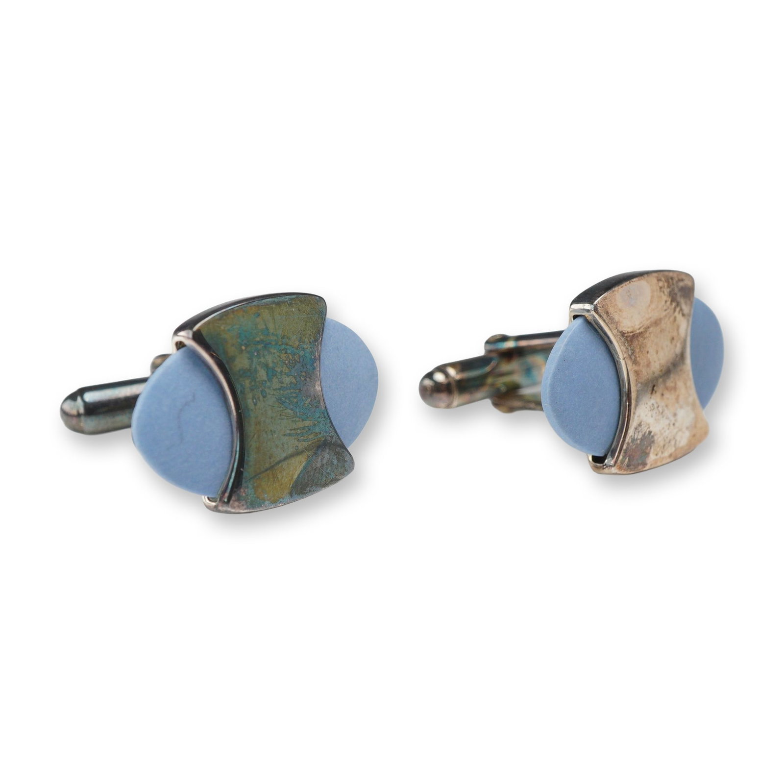 Pair of Wedgwood Sterling Silver and Blue Jasperware Modernist Cufflinks: Each cufflink consists of an oval, light blue matte-textured ceramic cabochon, characteristic of Jasperware, secured by a wide, curved sterling silver band. The pieces are fitted with standard swivel-