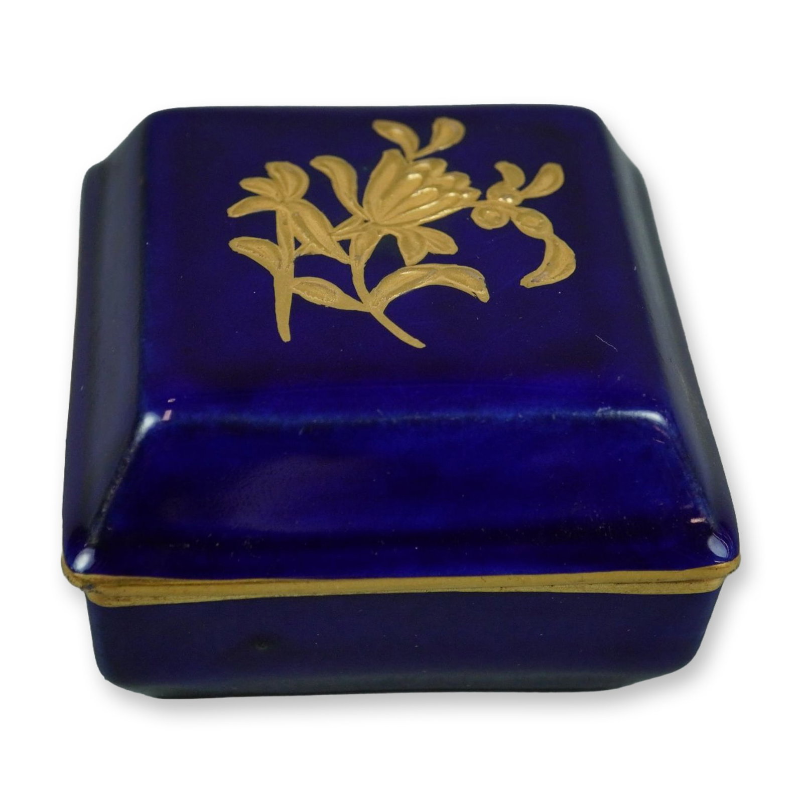 Wedgwood Cobalt Blue Porcelain Trinket Box with Gilt Floral Decoration: This square porcelain trinket box with a fitted lid was produced by Wedgwood. The exterior is finished in a rich cobalt blue glaze, and the lid is decorated with a central gilded floral sprig. The box