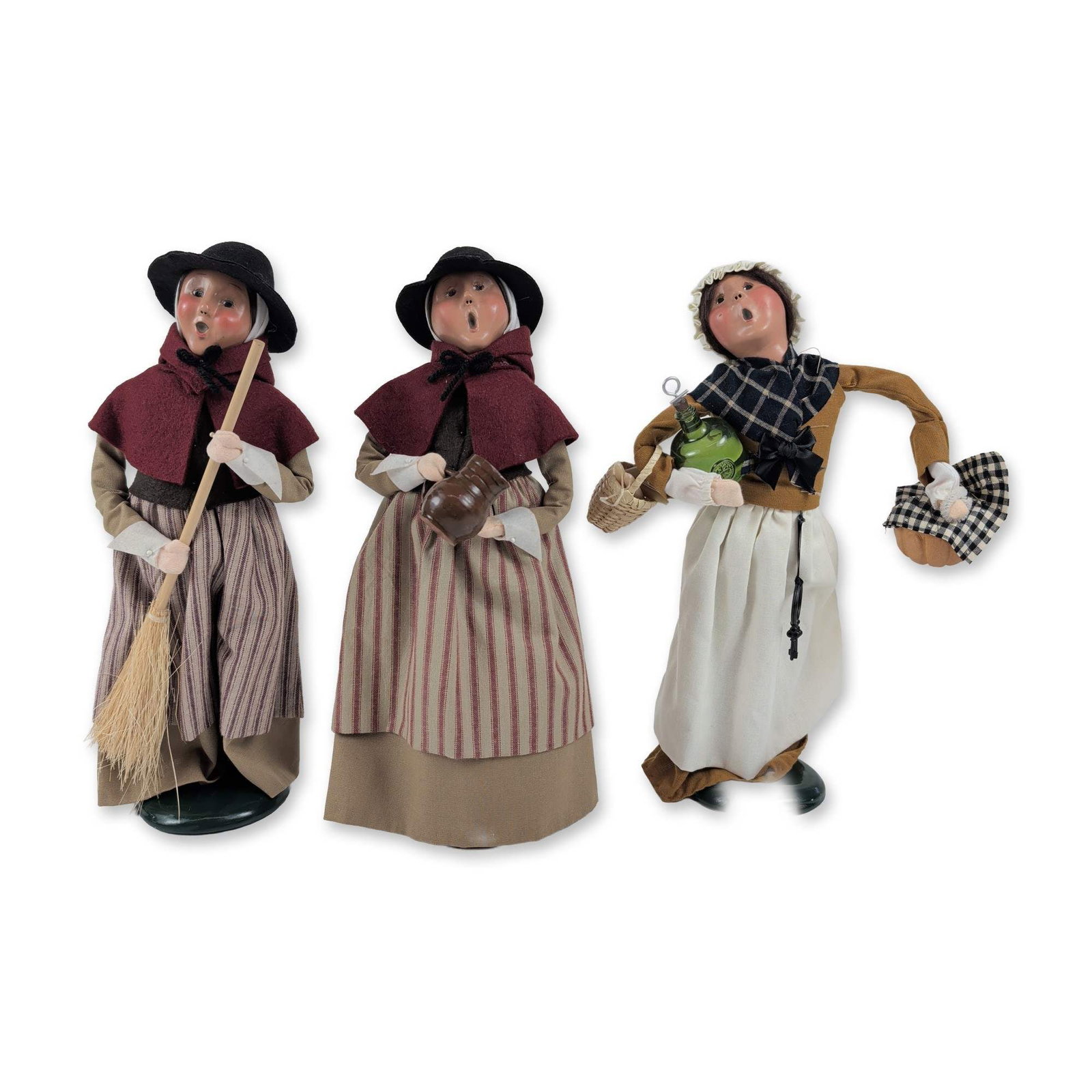 Trio of Byers Choice Caroler Figures: Byers Choice Ltd. trio of caroler figures featuring molded composition heads with hand-painted singing faces and wire-frame bodies. The grouping includes a Colonial Williamsburg edition dressed in a t