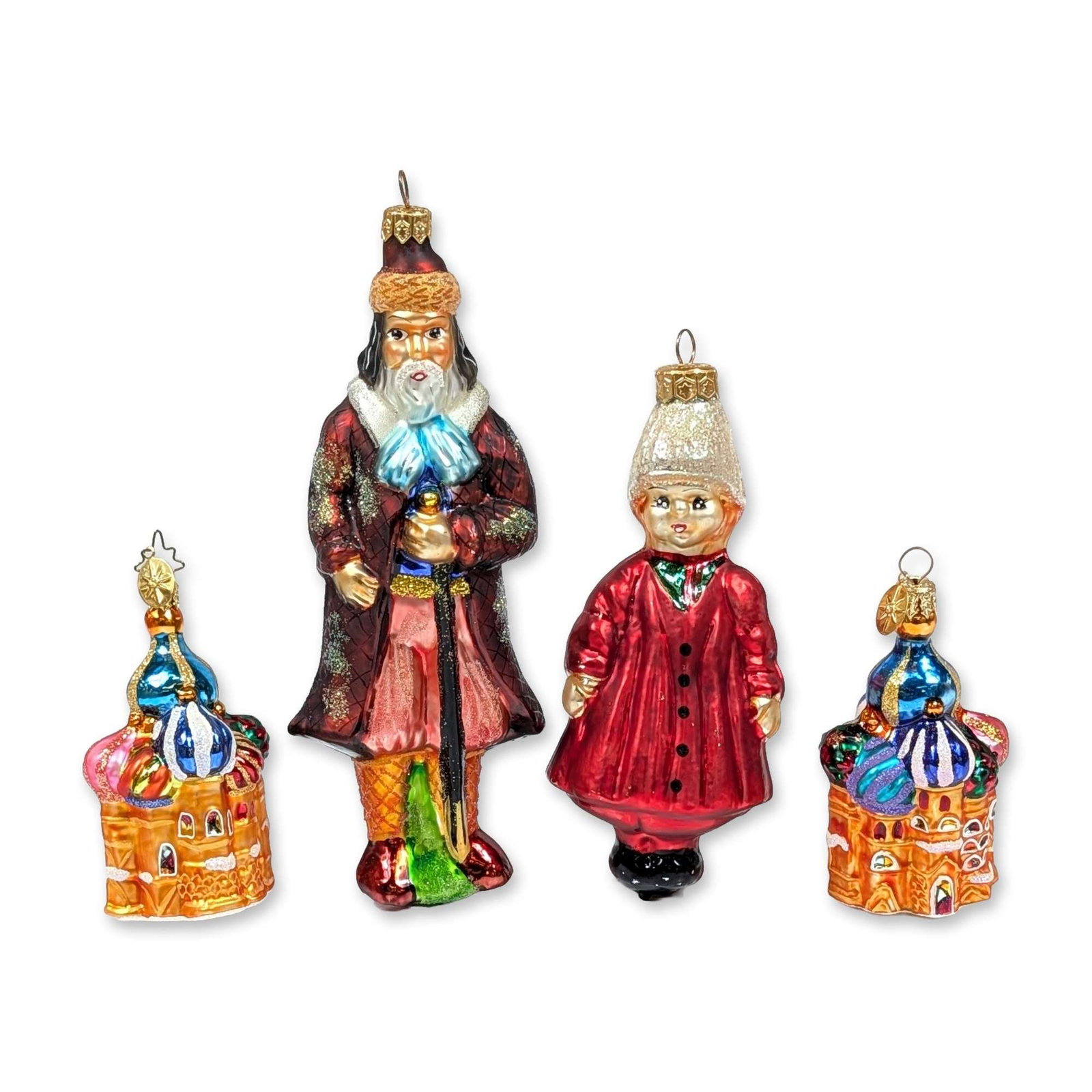 Christopher Radko Russian Rhapsody Ornament Set: Christopher Radko, 1996. Set of Christmas ornaments in hand-blown glass from the Russian Rhapsody collection, featuring a Ded Moroz figure in a patterned dark red coat, a Maiden figure in a red coat w